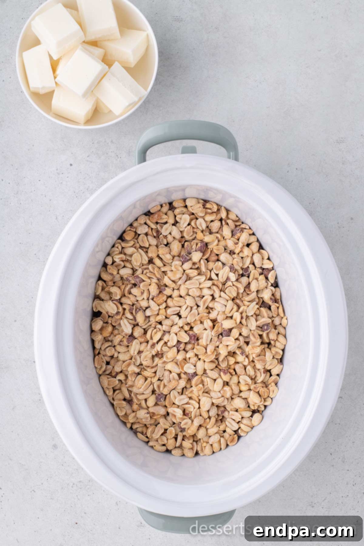 Peanuts layered on top of chocolate in a crock pot.