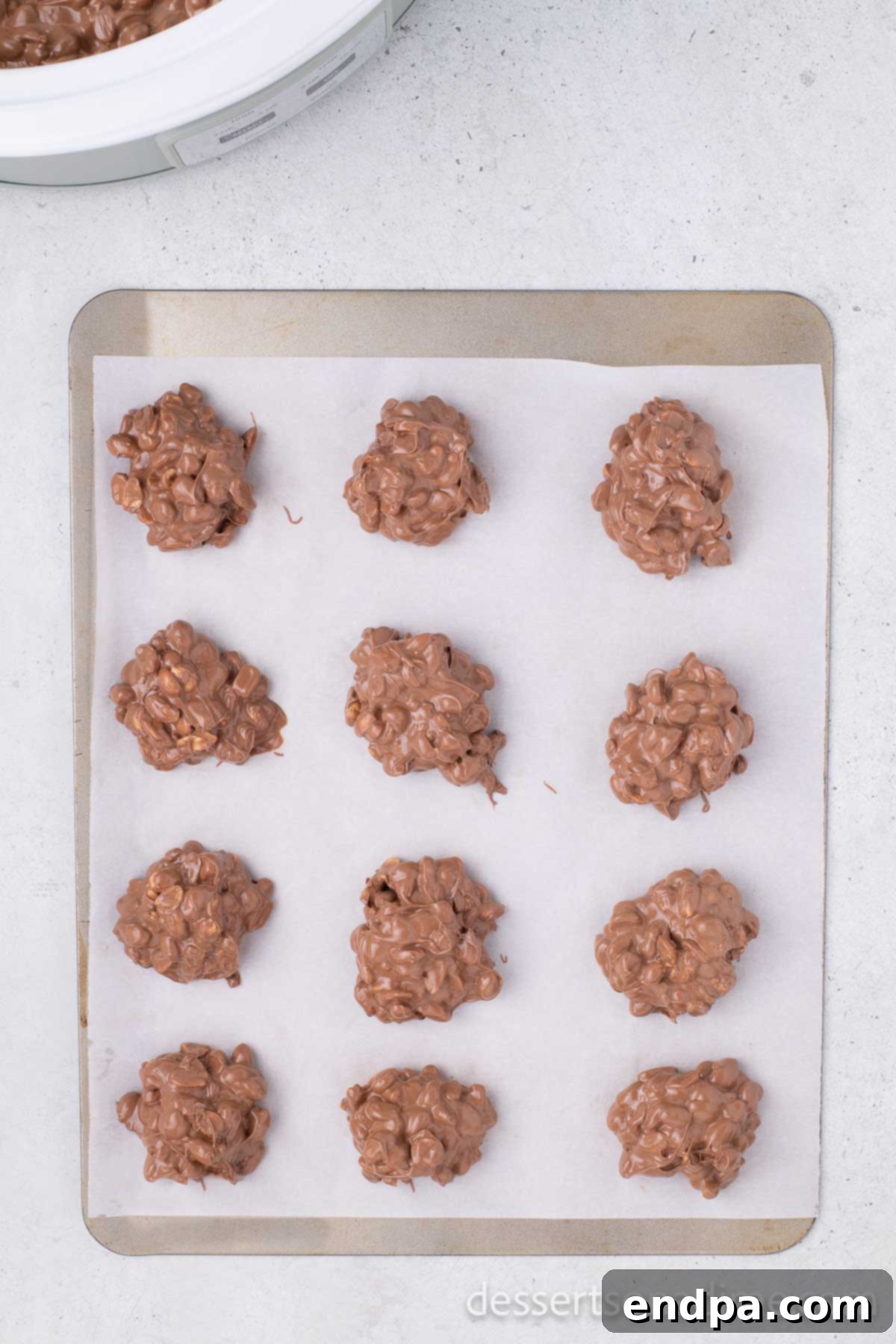Candy scooped into mounds on a baking sheet, waiting for sprinkles.