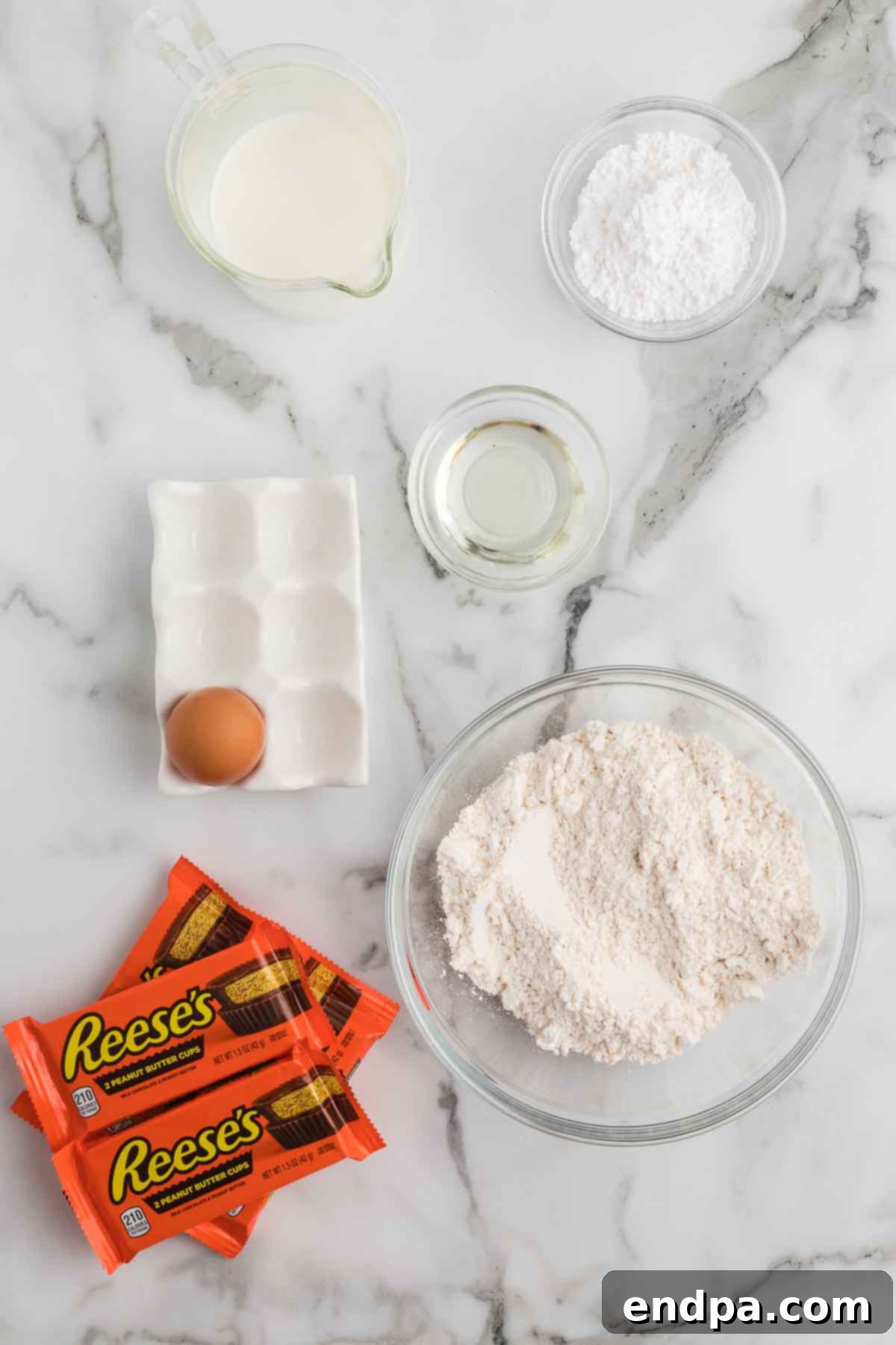Ingredients for deep fried reese's peanut butter cups. - peanut butter cups, pancake mix, egg, milk, oil, powdered sugar.