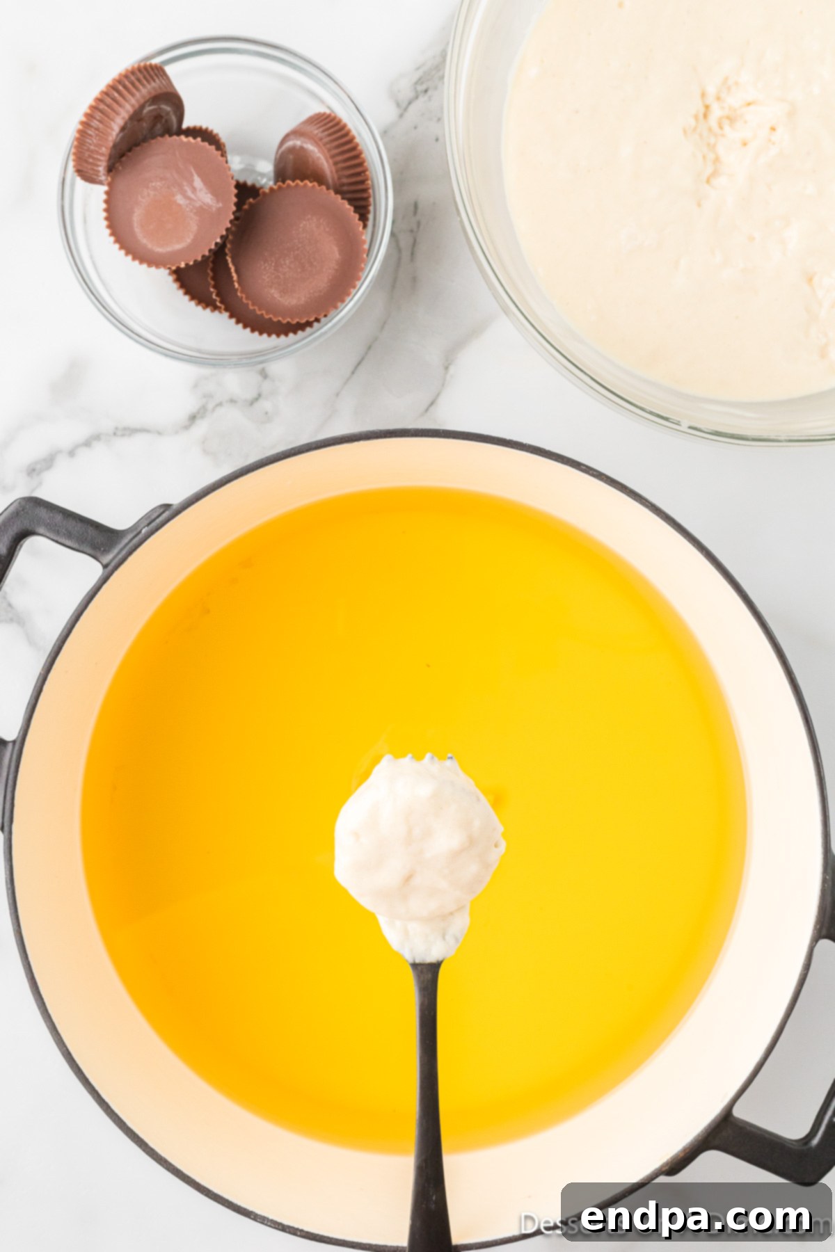 Reece's Cup dipped in batter and placed into hot oil.