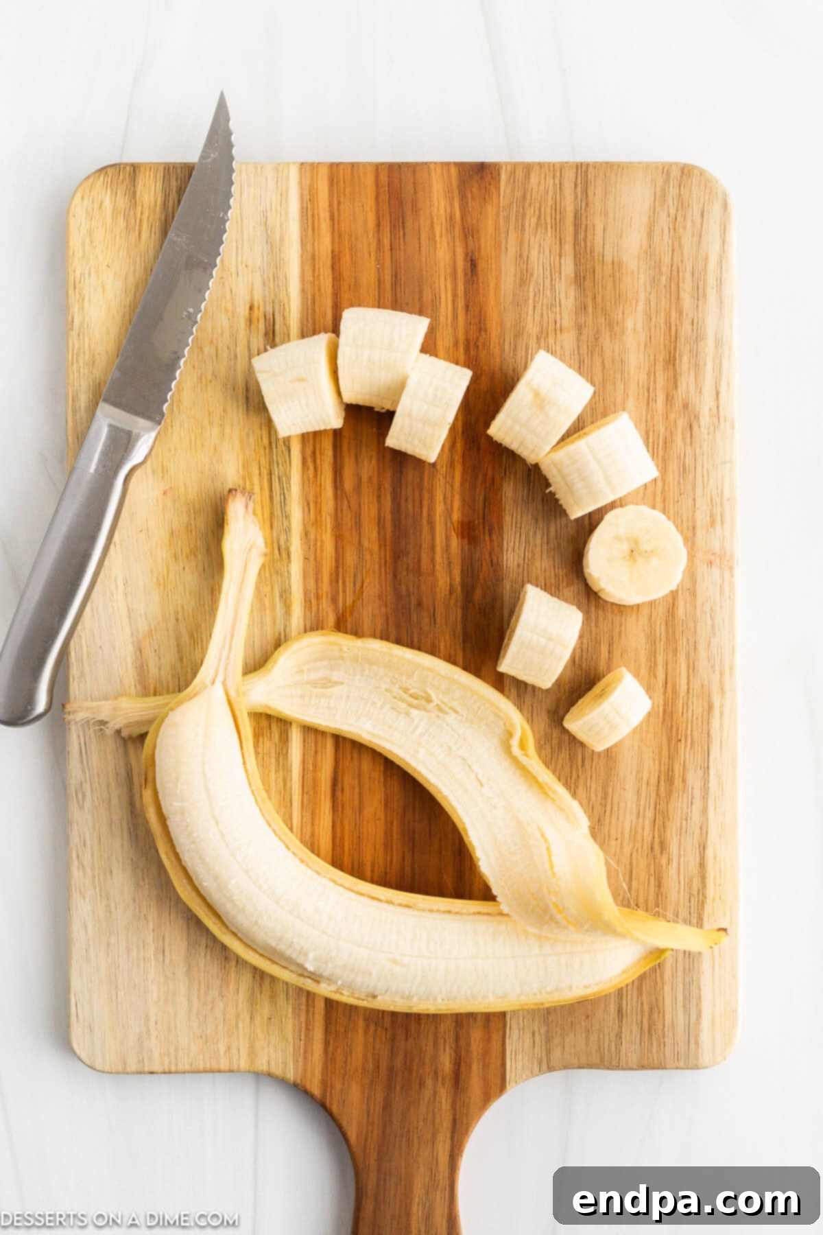 Bananas sliced evenly into rounds on a cutting board.