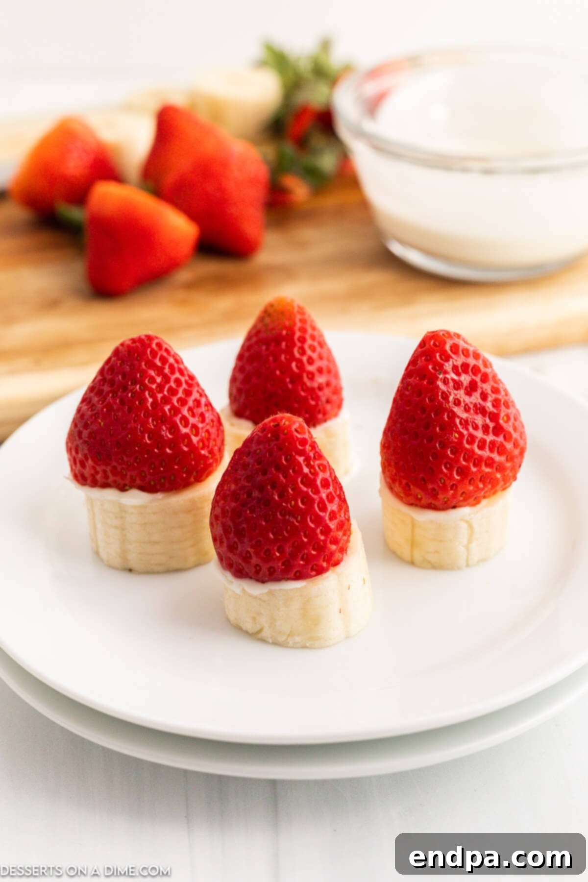 Strawberries placed on top of chocolate-coated banana slices.