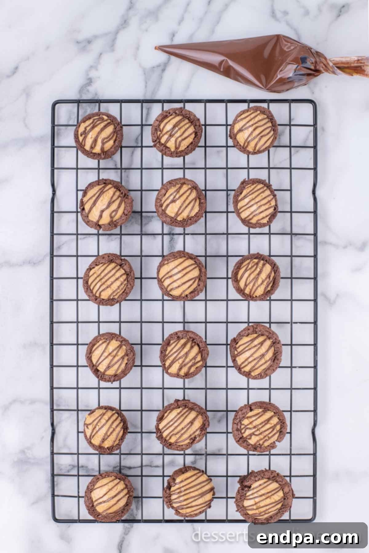 Peanut Butter Brownie Bliss Bites 11 Chocolate glaze being drizzled over cooled Buckeye brownie bites on a wire rack.