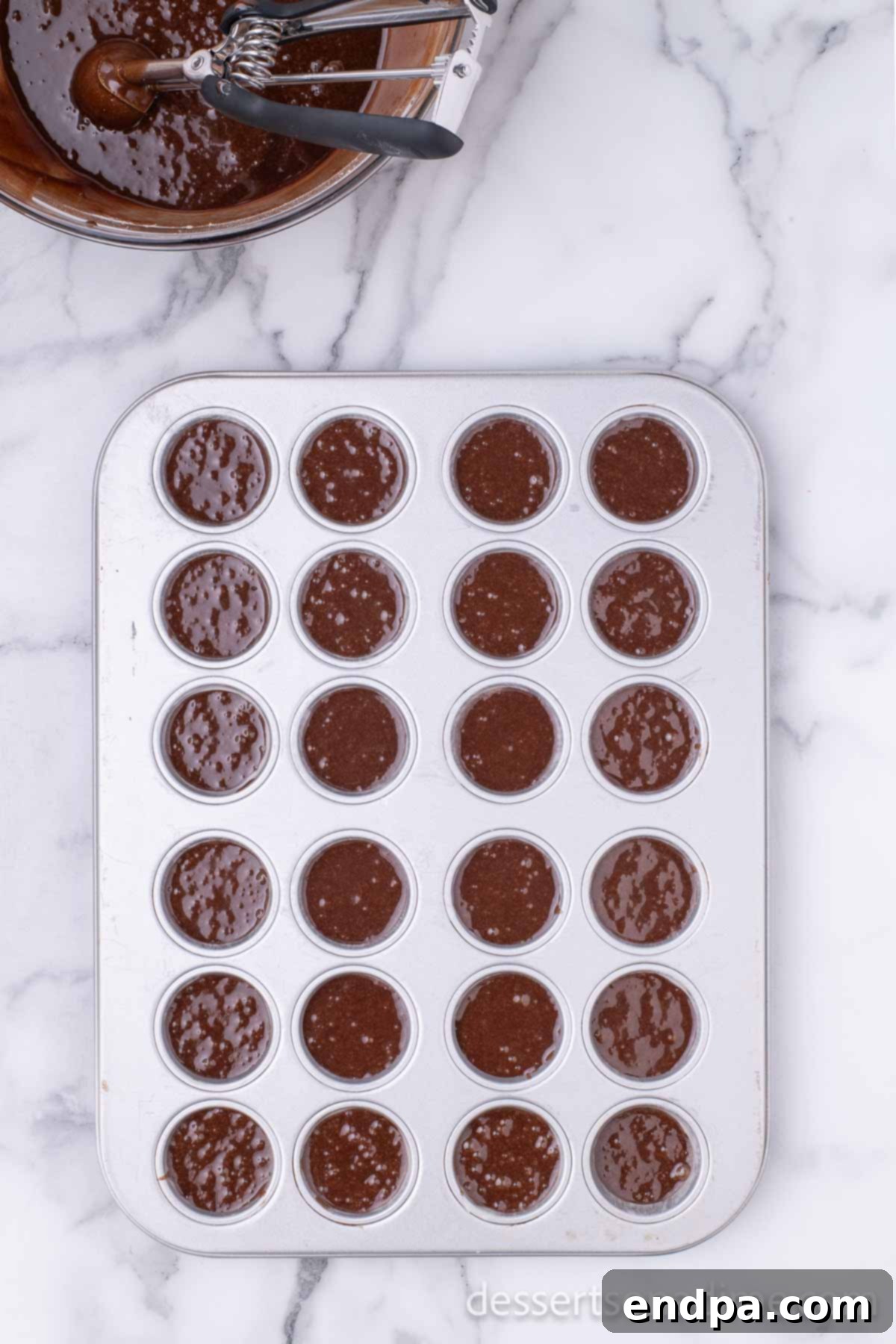 Peanut Butter Brownie Bliss Bites 7 Brownie batter neatly poured into mini muffin cups in a baking tin.