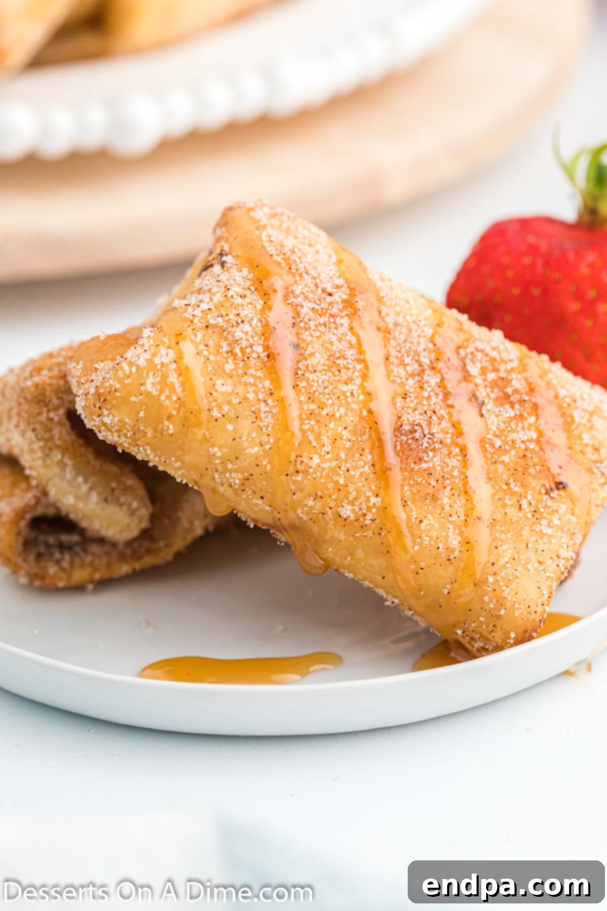 Crispy Cheesecake Chimis 11 A close-up shot of several cheesecake chimichangas, perfectly fried and coated in cinnamon sugar, ready to be enjoyed.
