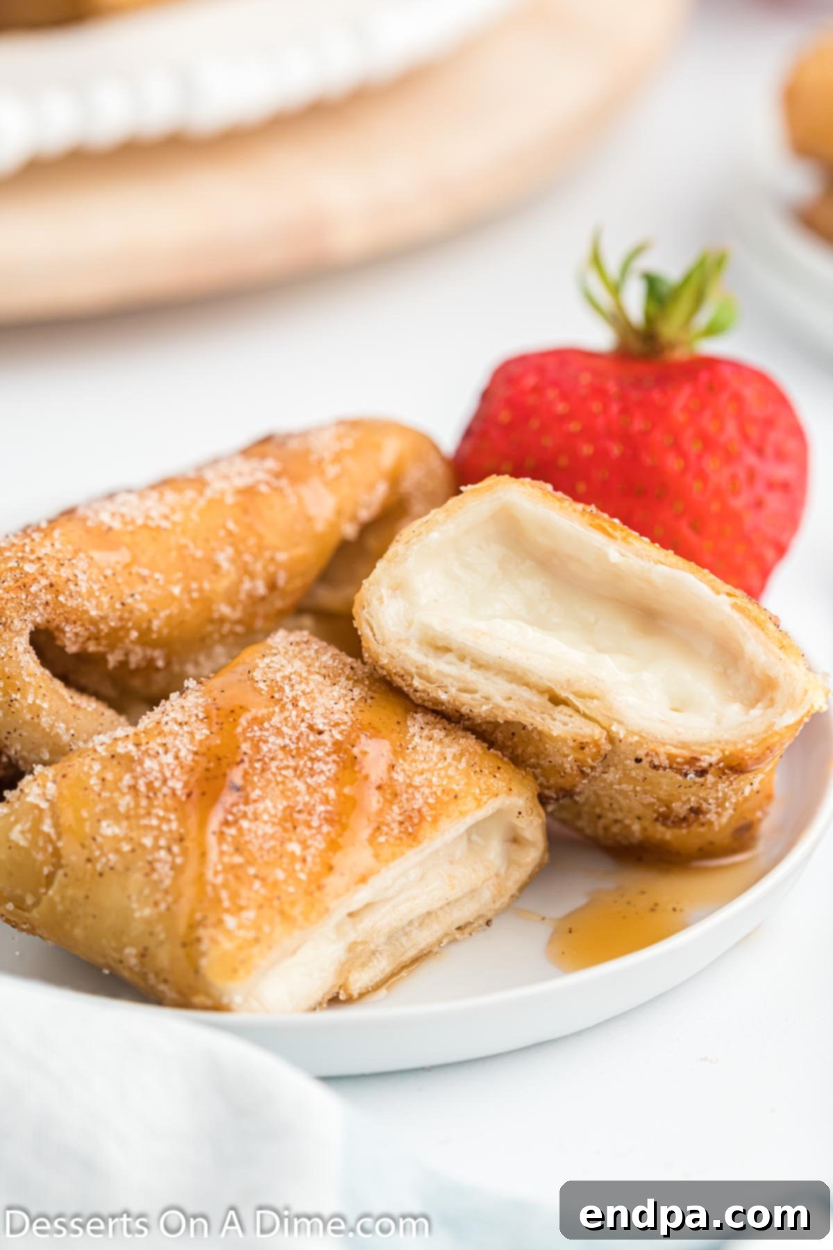 Crispy Cheesecake Chimis 10 Cheesecake chimichangas, cut in half to show the creamy filling, beautifully arranged on a platter.