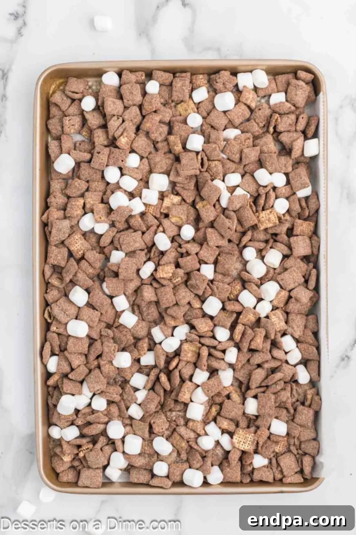 Decadent Hot Chocolate Puppy Chow 9 Hot chocolate puppy chow spread on a baking sheet with mini marshmallows.