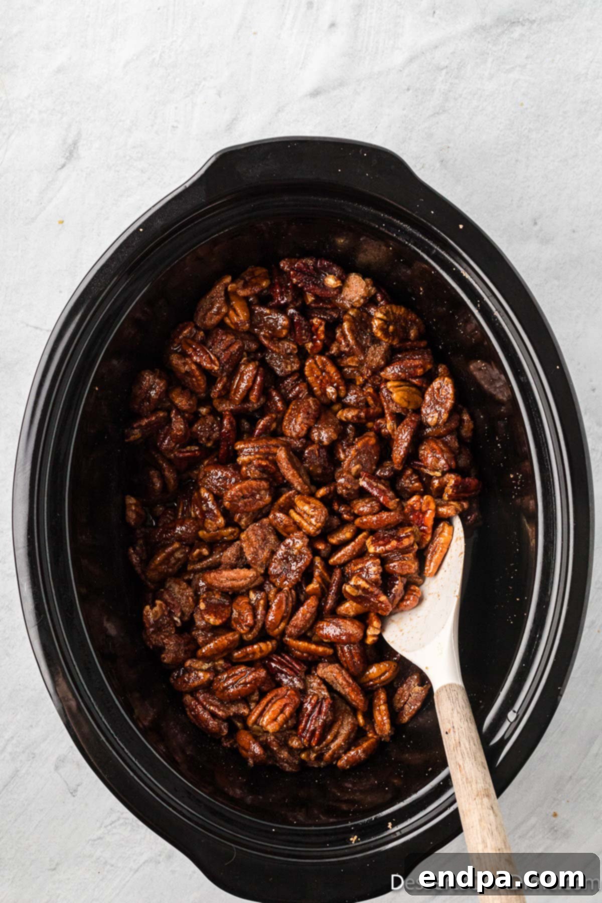 Pecan mixture stirred with a spoon. 