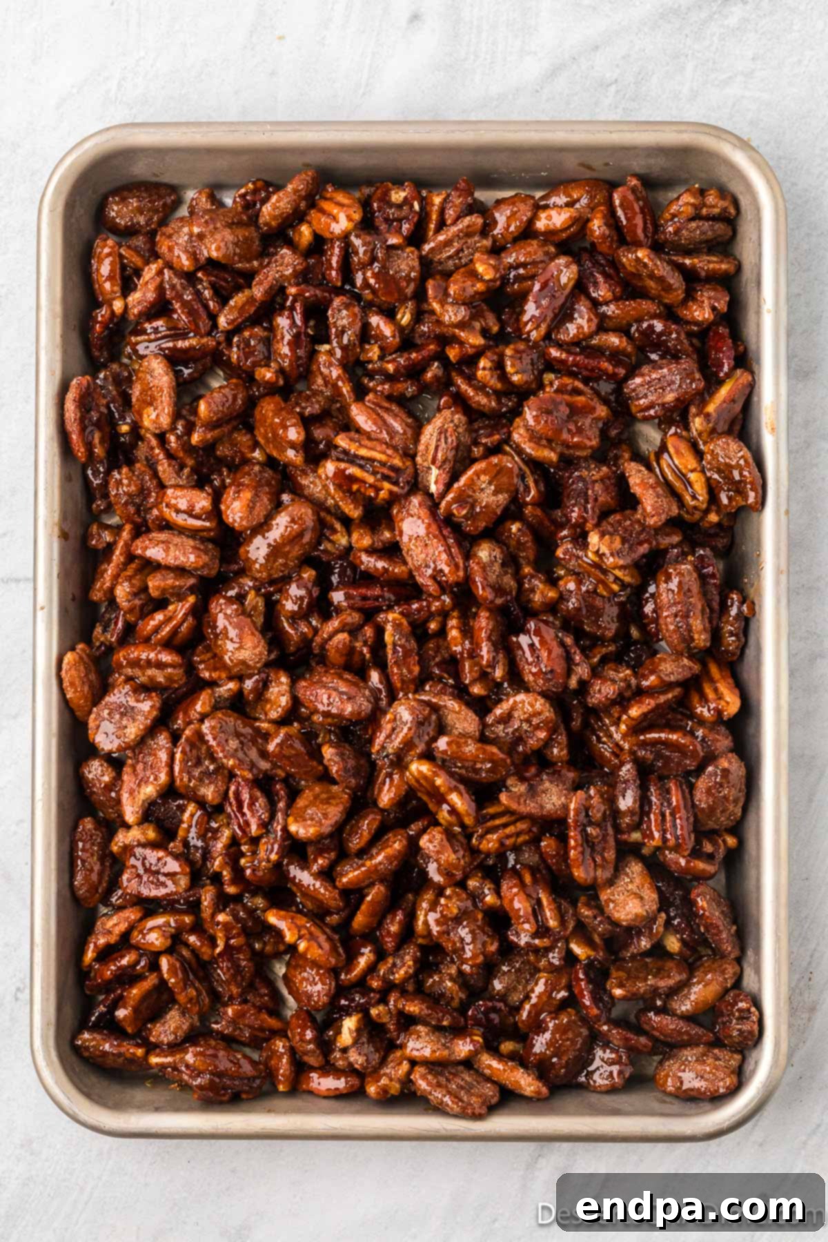Pecans spread on a baking sheet to cool. 