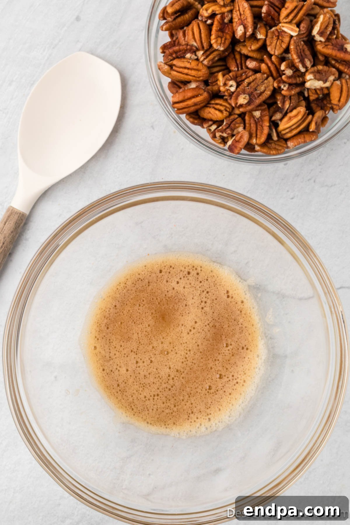 Egg whites and vanilla combined in a bowl. 