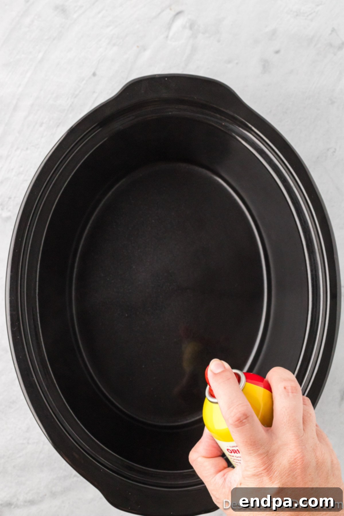 Slow cooker coated in cooking spray.