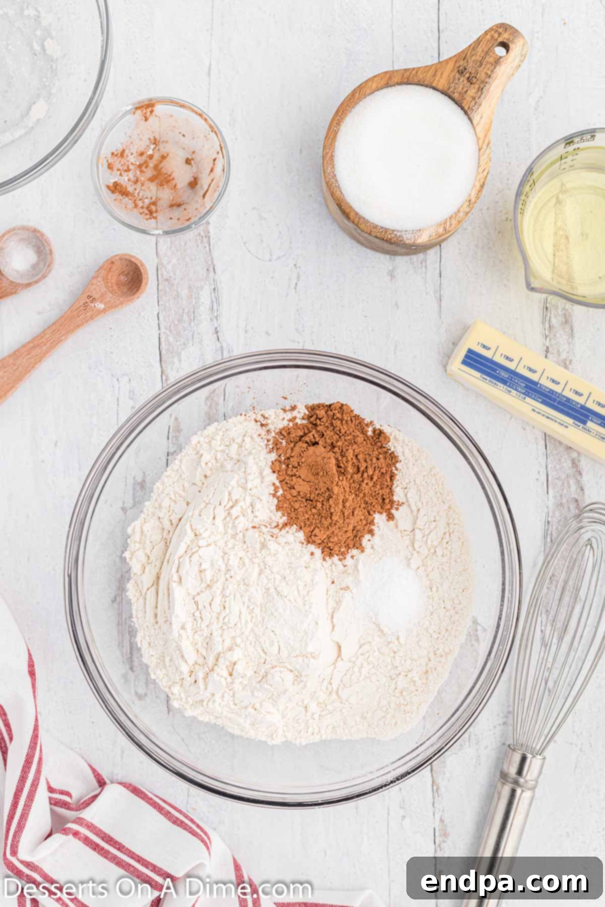 A bowl of whisked dry ingredients for Red Velvet Pound Cake, including flour, cocoa powder, baking soda, and salt.