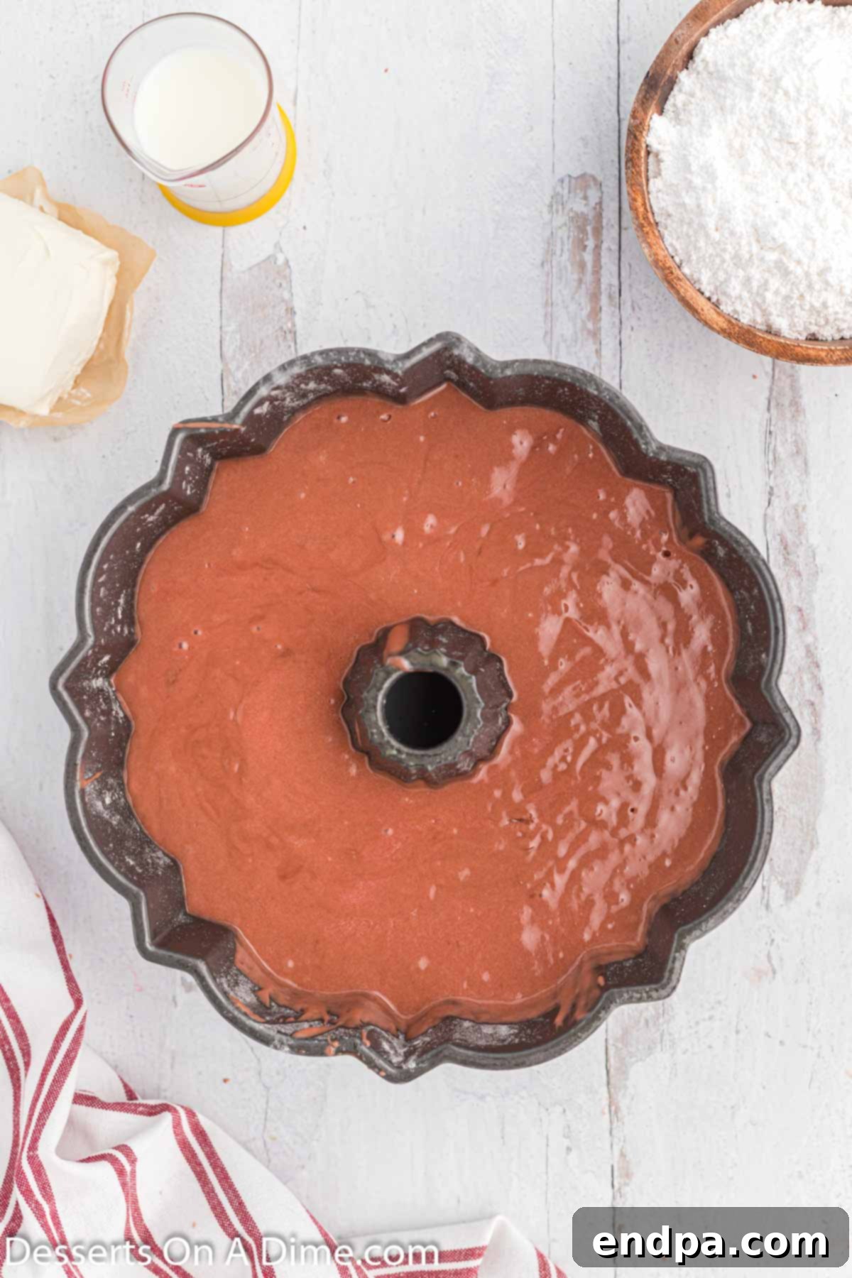 Red Velvet Pound Cake batter poured smoothly into a bundt cake pan, ready for baking.
