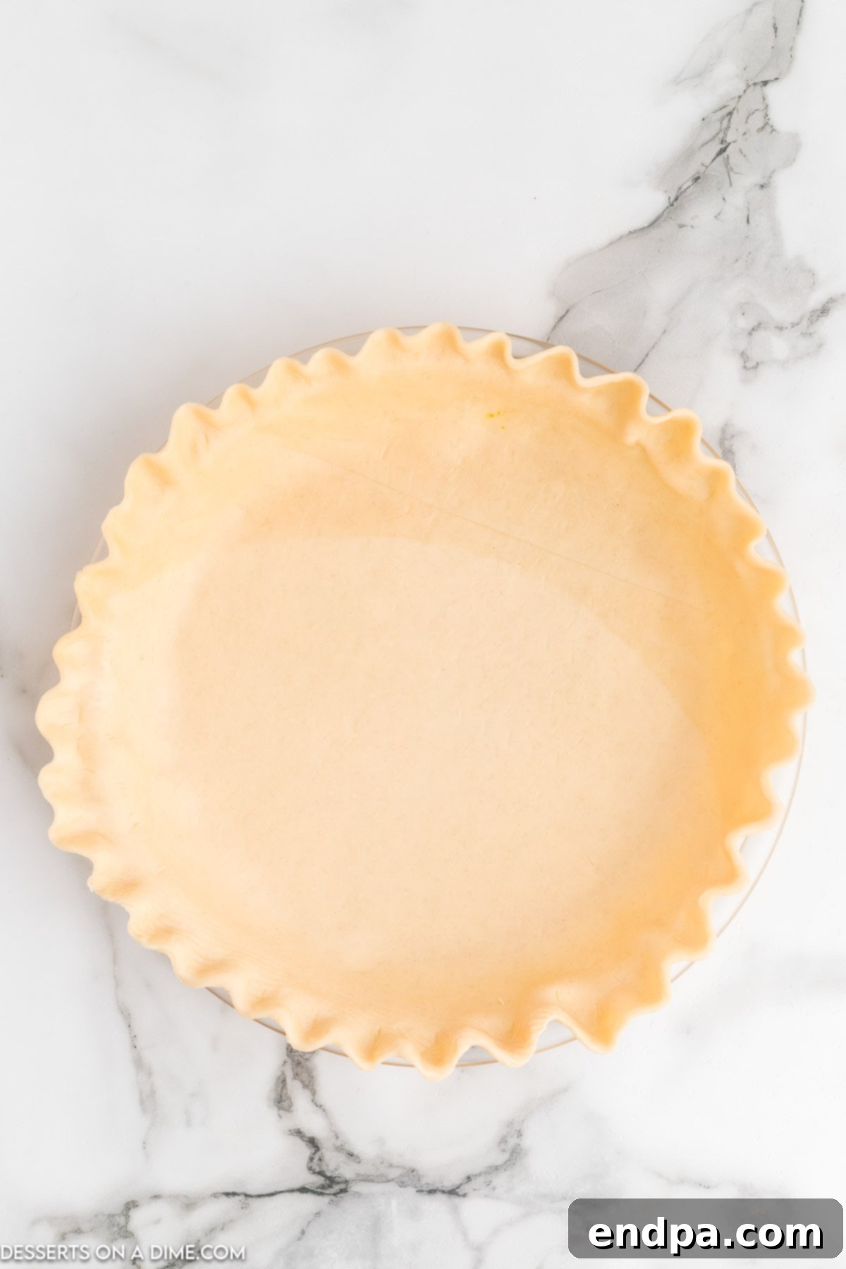 A golden, ready-to-fill pie crust nestled perfectly in a 9-inch pie plate, with crimped edges awaiting its delicious filling.