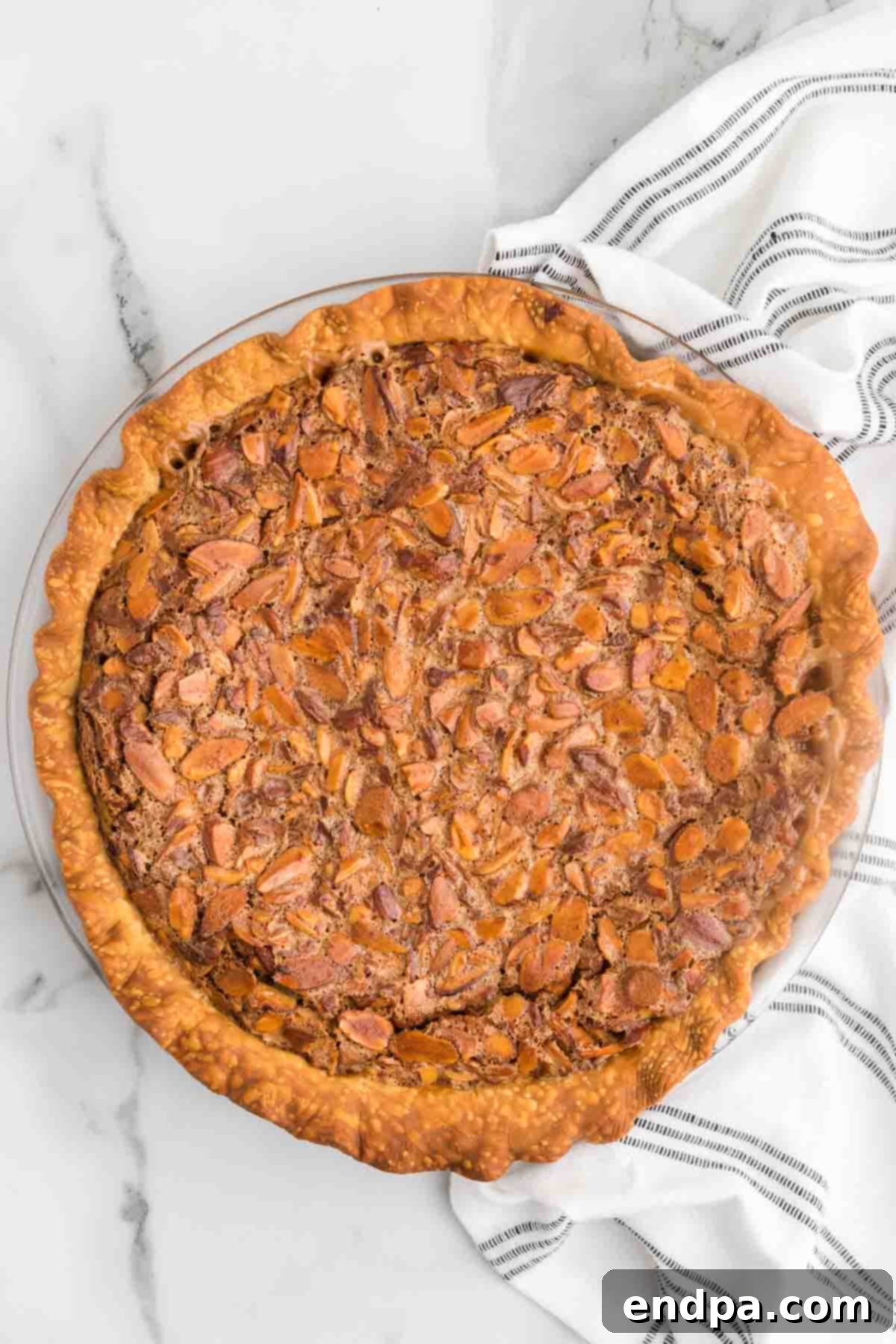 A perfectly baked Toffee Almond Pie, golden brown and firm, waiting to be cut into elegant slices.