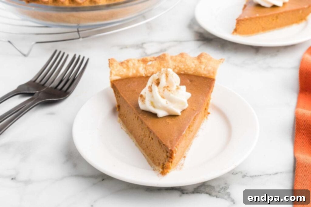 Luscious Dulce De Leche Pumpkin Pie 2 A beautifully baked Dulce de Leche Pumpkin Pie on a plate, garnished with a dollop of whipped cream, ready to be served.