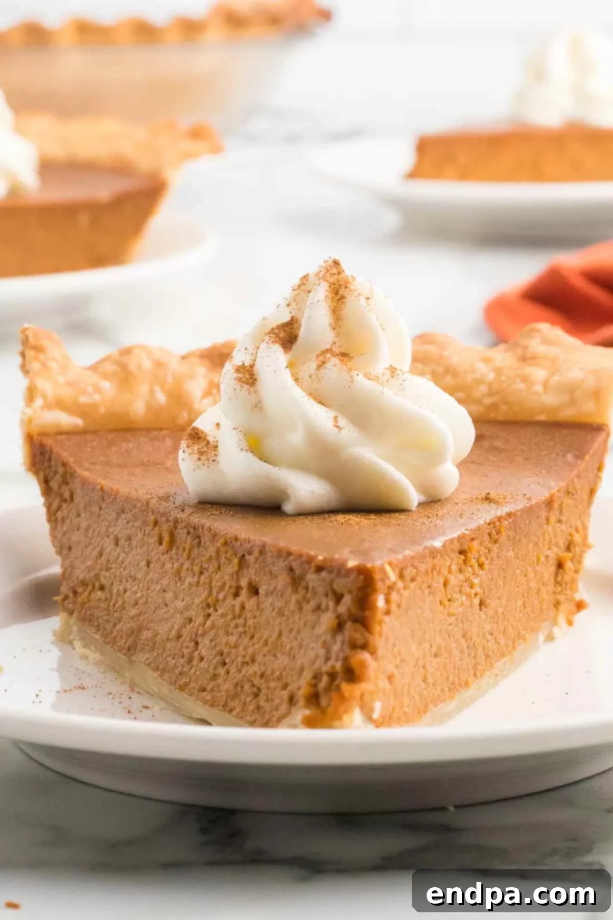 Luscious Dulce De Leche Pumpkin Pie 6 A delectable slice of Dulce De Leche Pumpkin Pie, perfectly set, with a generous swirl of cool whip on top, ready to be enjoyed.