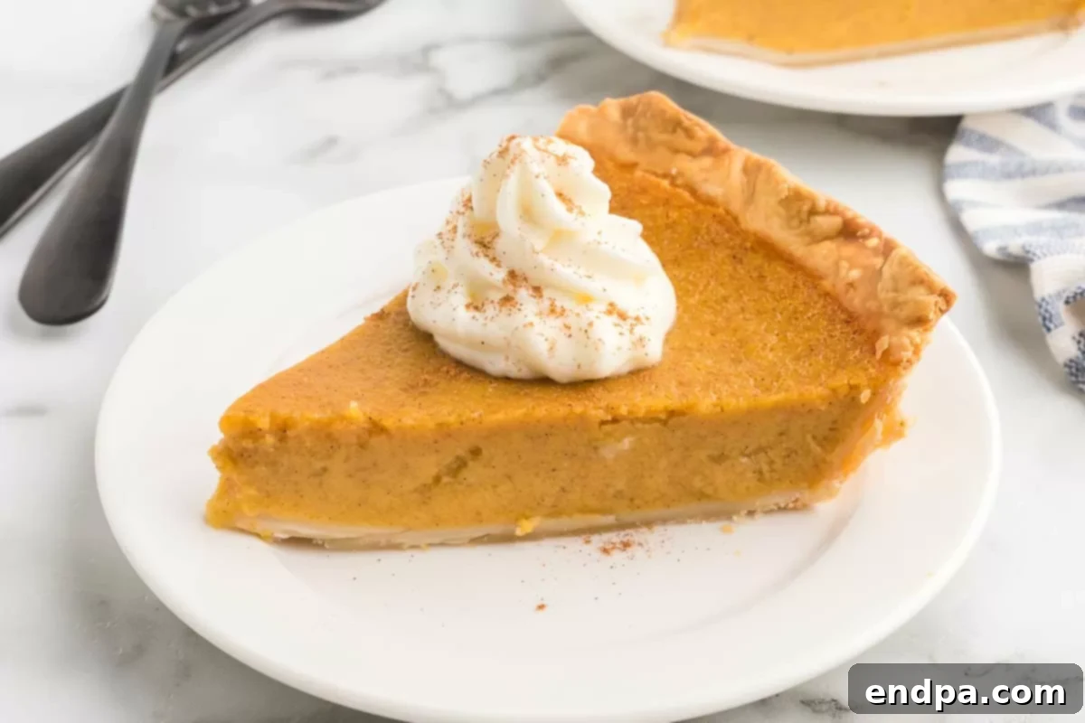Golden Harvest Butternut Squash Pie 2 Slice of Butternut squash pie on a white plate, ready to be enjoyed.