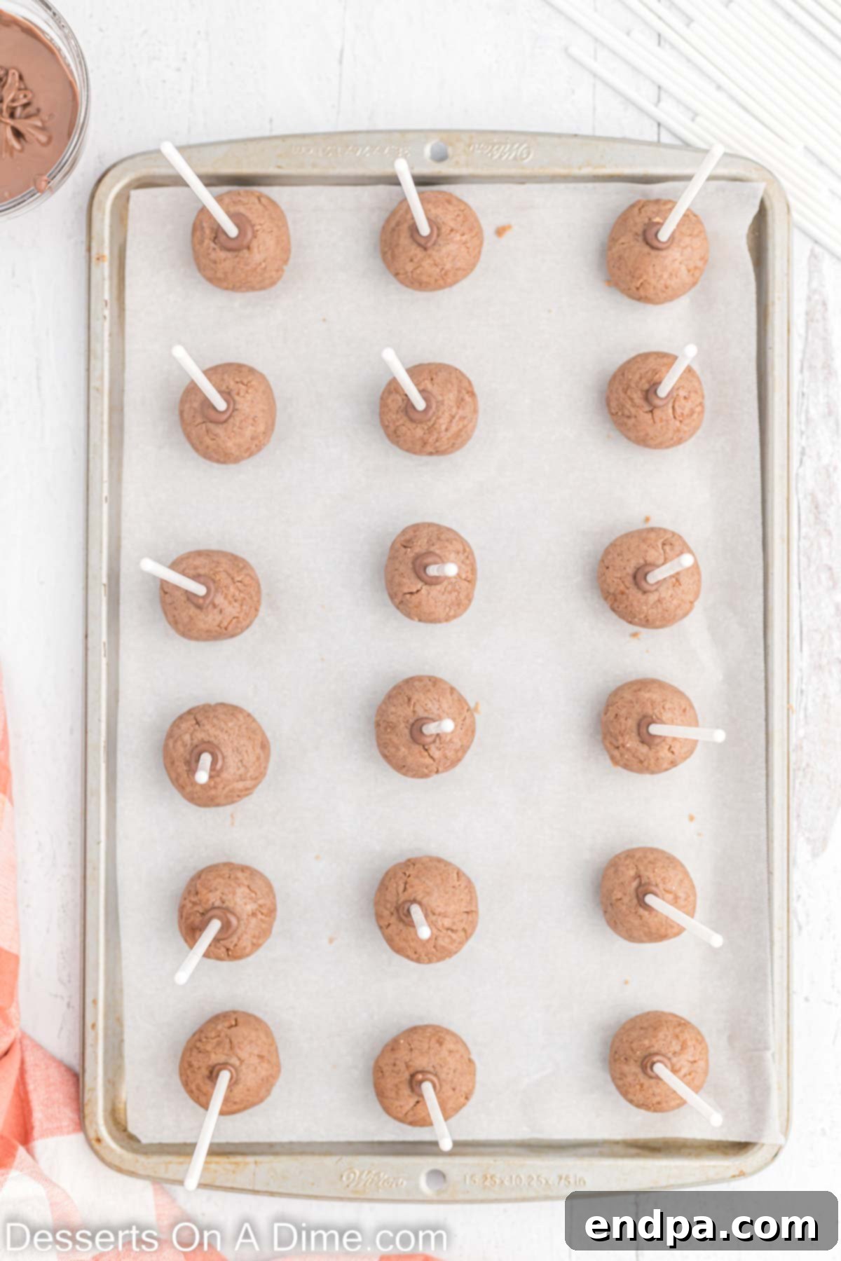 Cake Pop sticks inserted into balls on baking sheet.