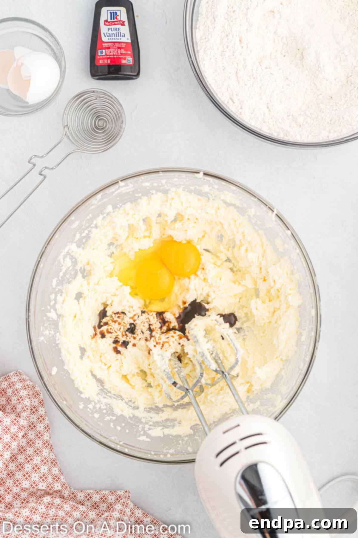 Mixing bowl with creamed butter, sugar, and added eggs and vanilla.