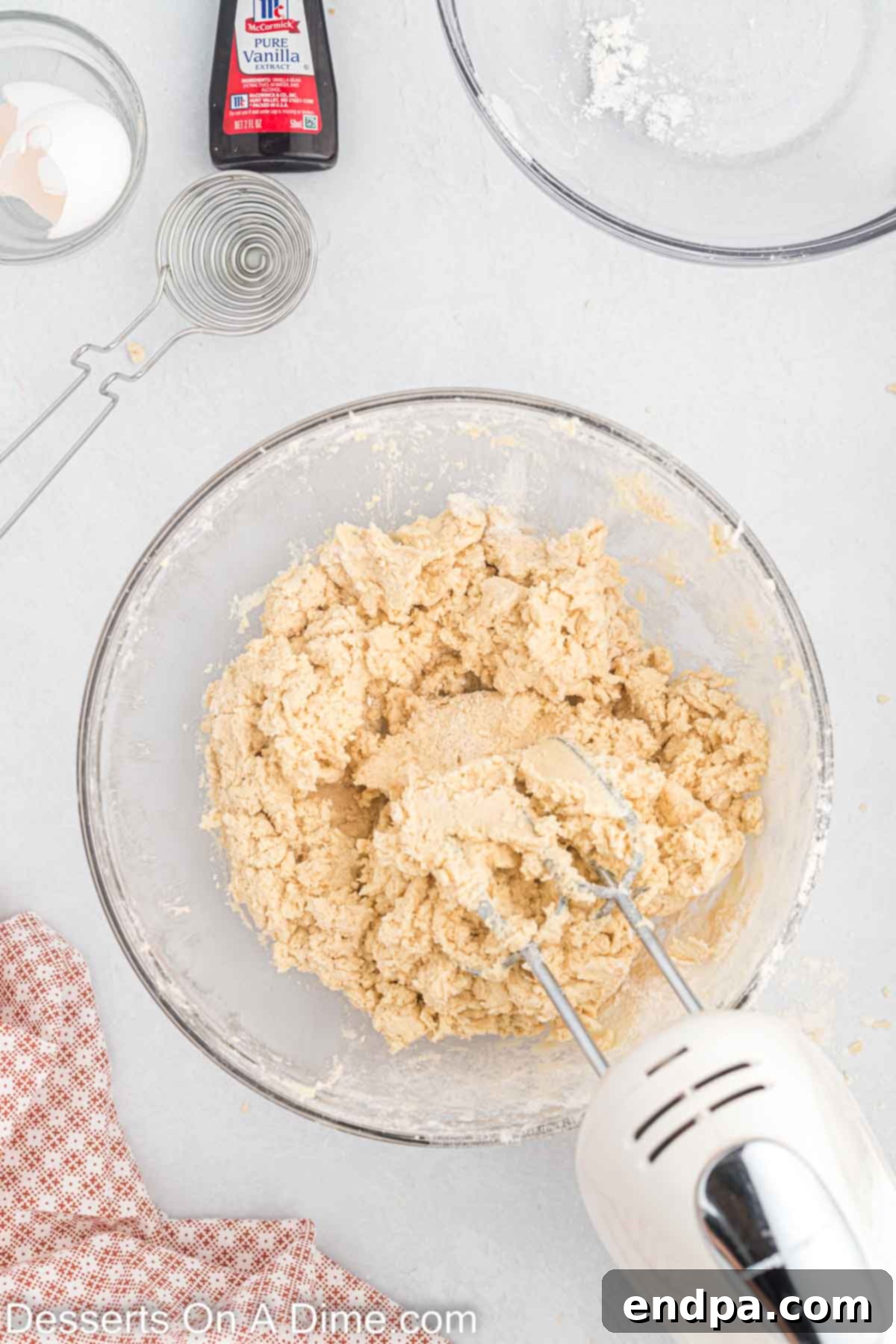 Flour mixture slowly being added to the wet ingredients in a mixing bowl.