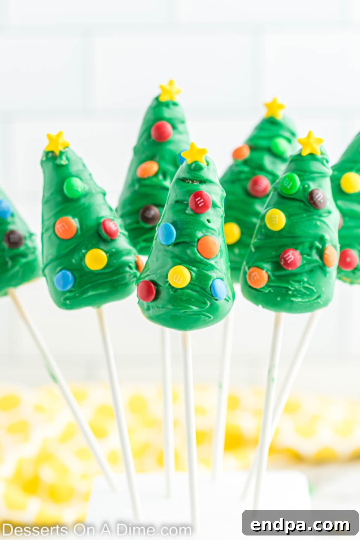Christmas Tree Cake Pops in a stand, beautifully decorated for the holidays.