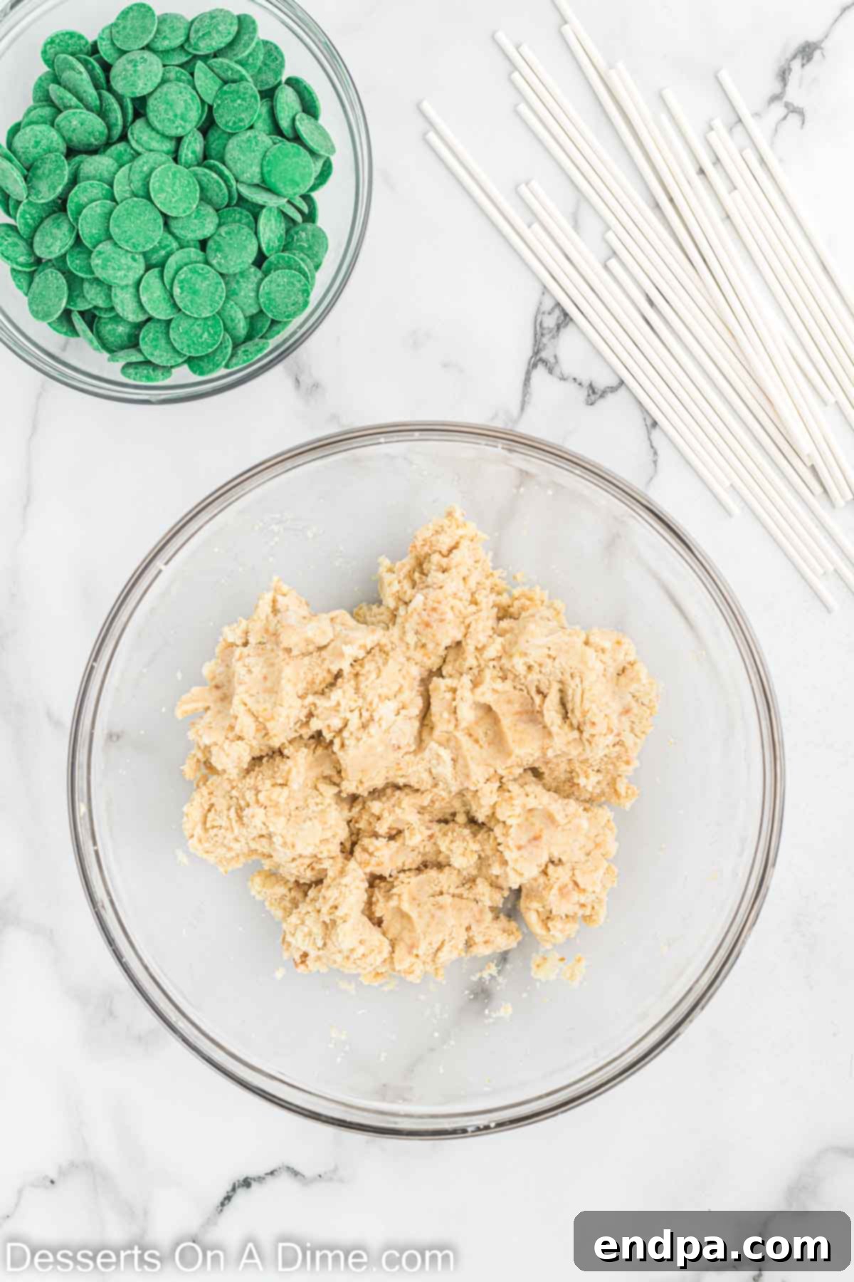 Mixing bowl with crumbled cake and vanilla frosting combined.