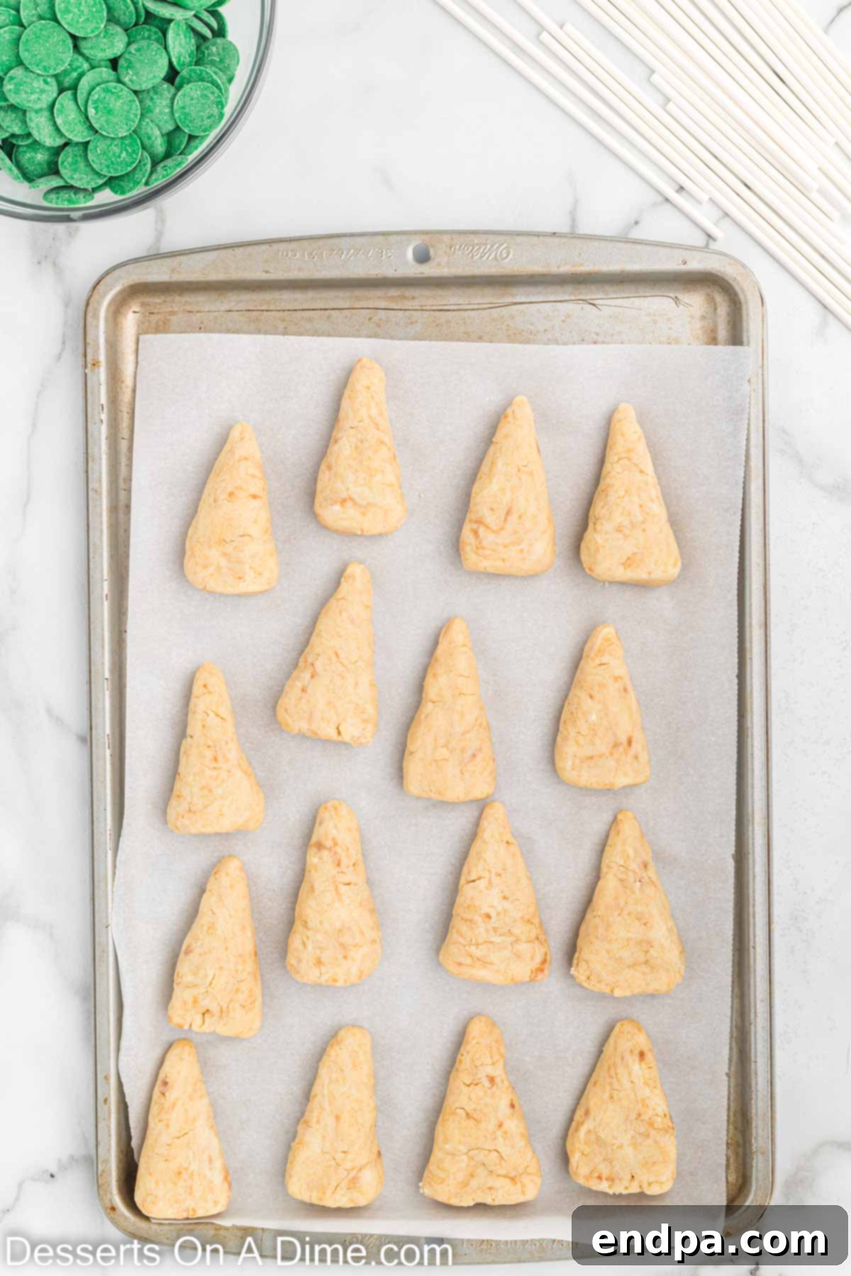 Cone-shaped cake pop bases arranged on a cookie sheet.