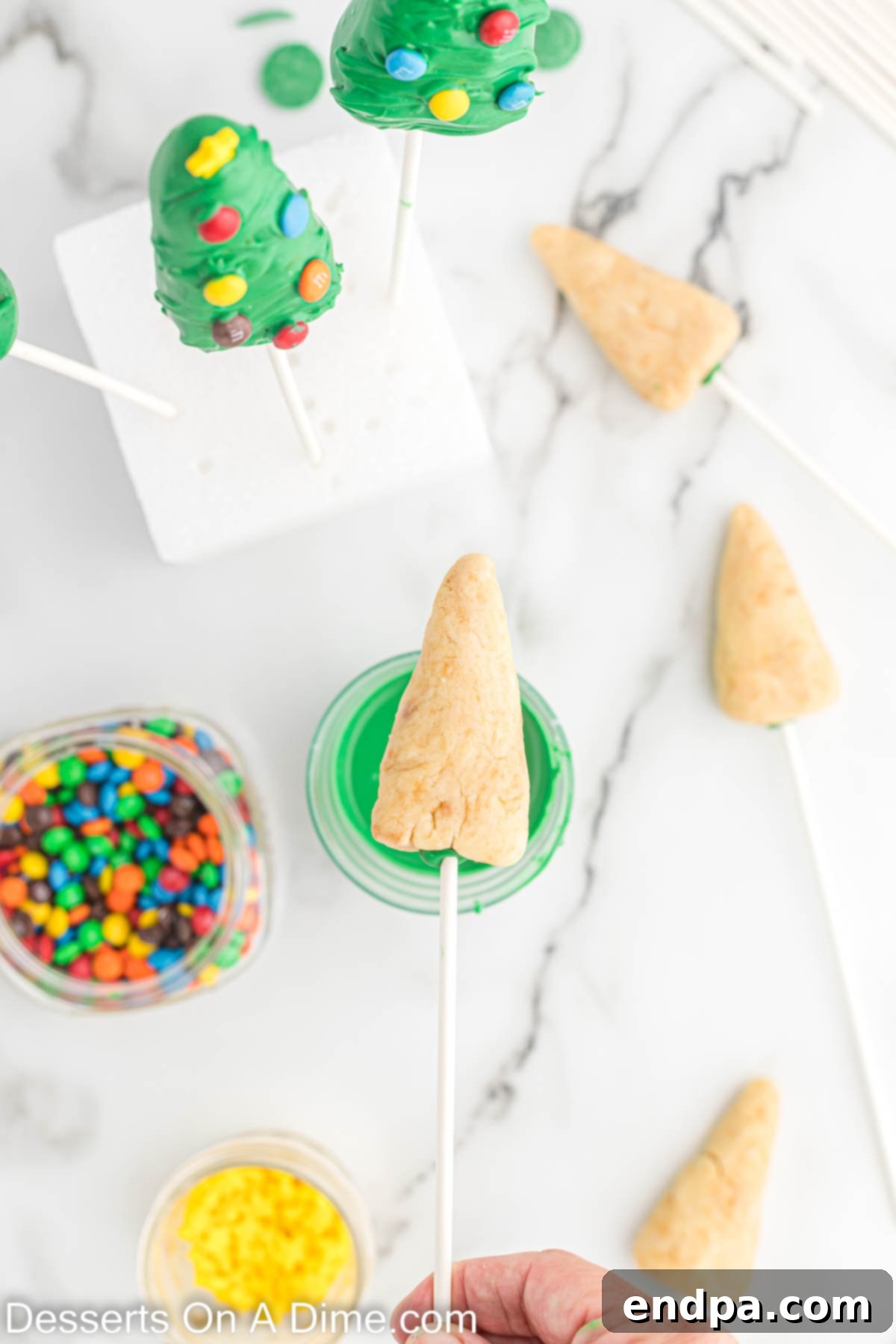 A cake pop tree ready to be dipped in melted green candy.