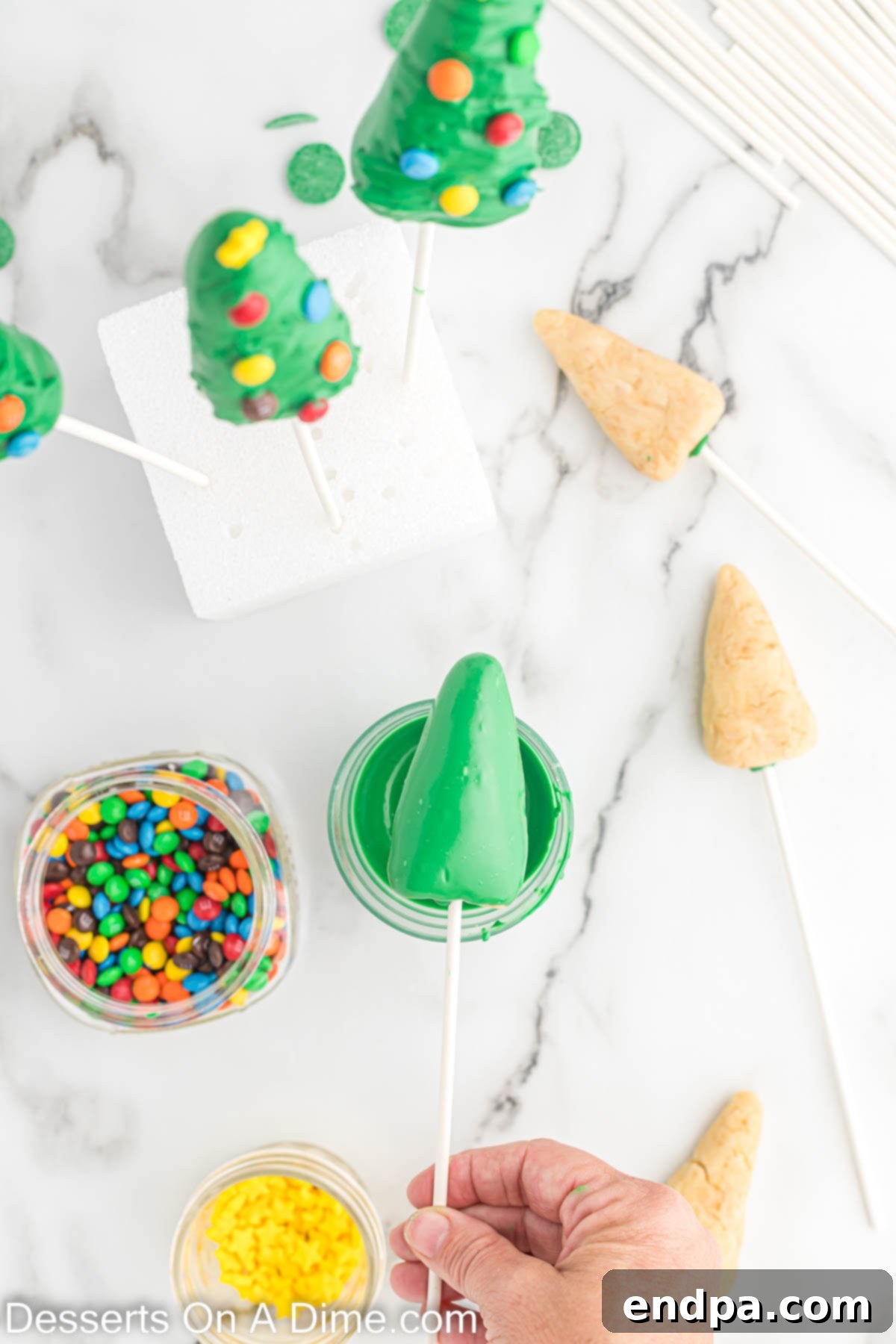A cake pop tree coated in green candy melts with branch texture created.