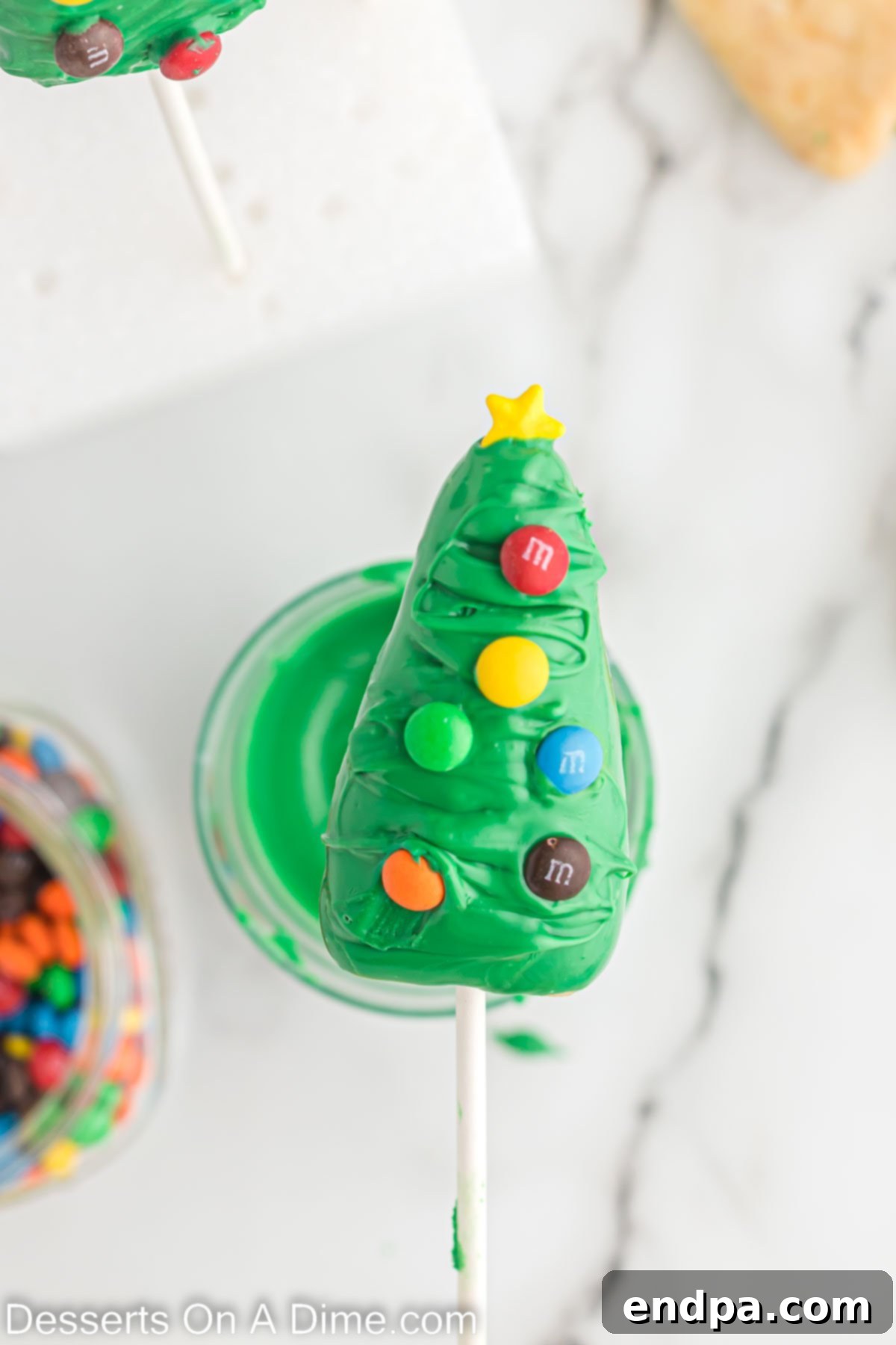 A decorated cake pop tree with mini M&Ms and a star sprinkle.