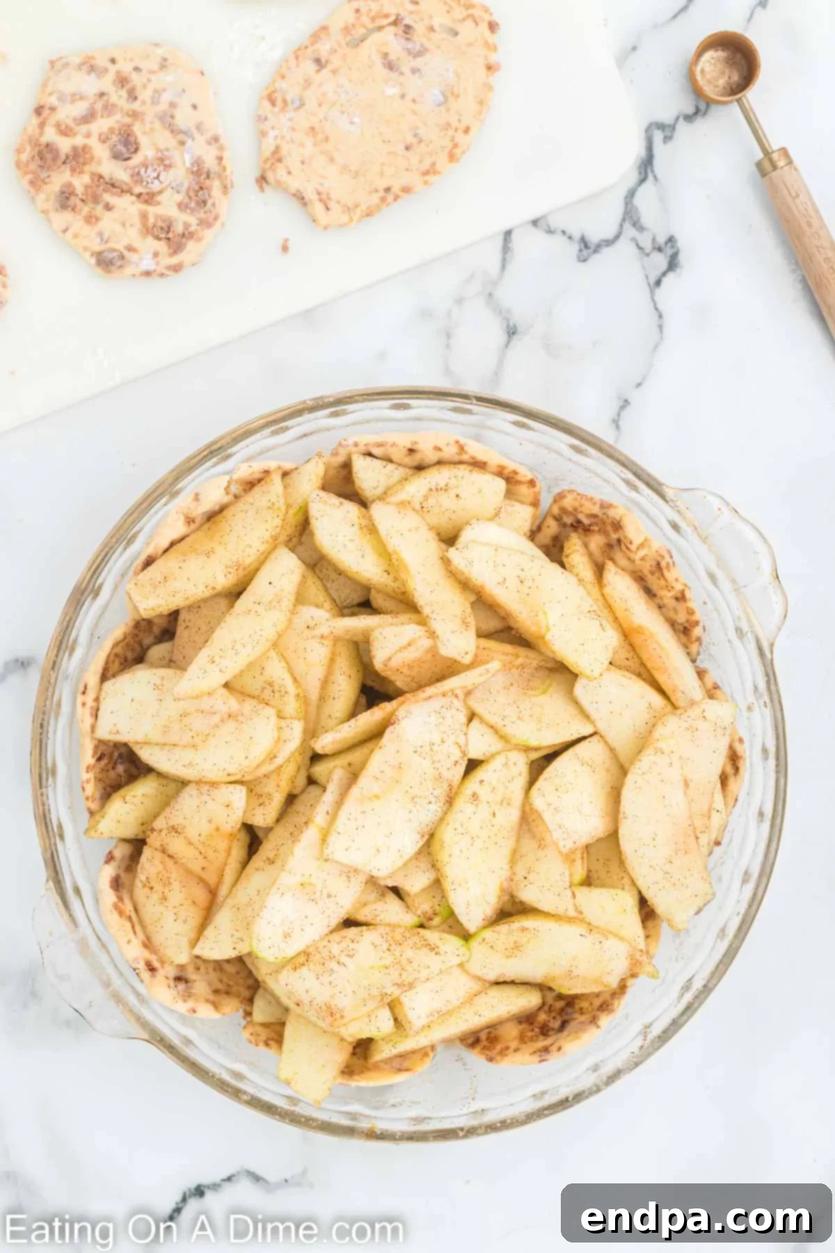 Sliced apples mixed with lemon juice and spices, layered over the partially baked cinnamon roll crust.