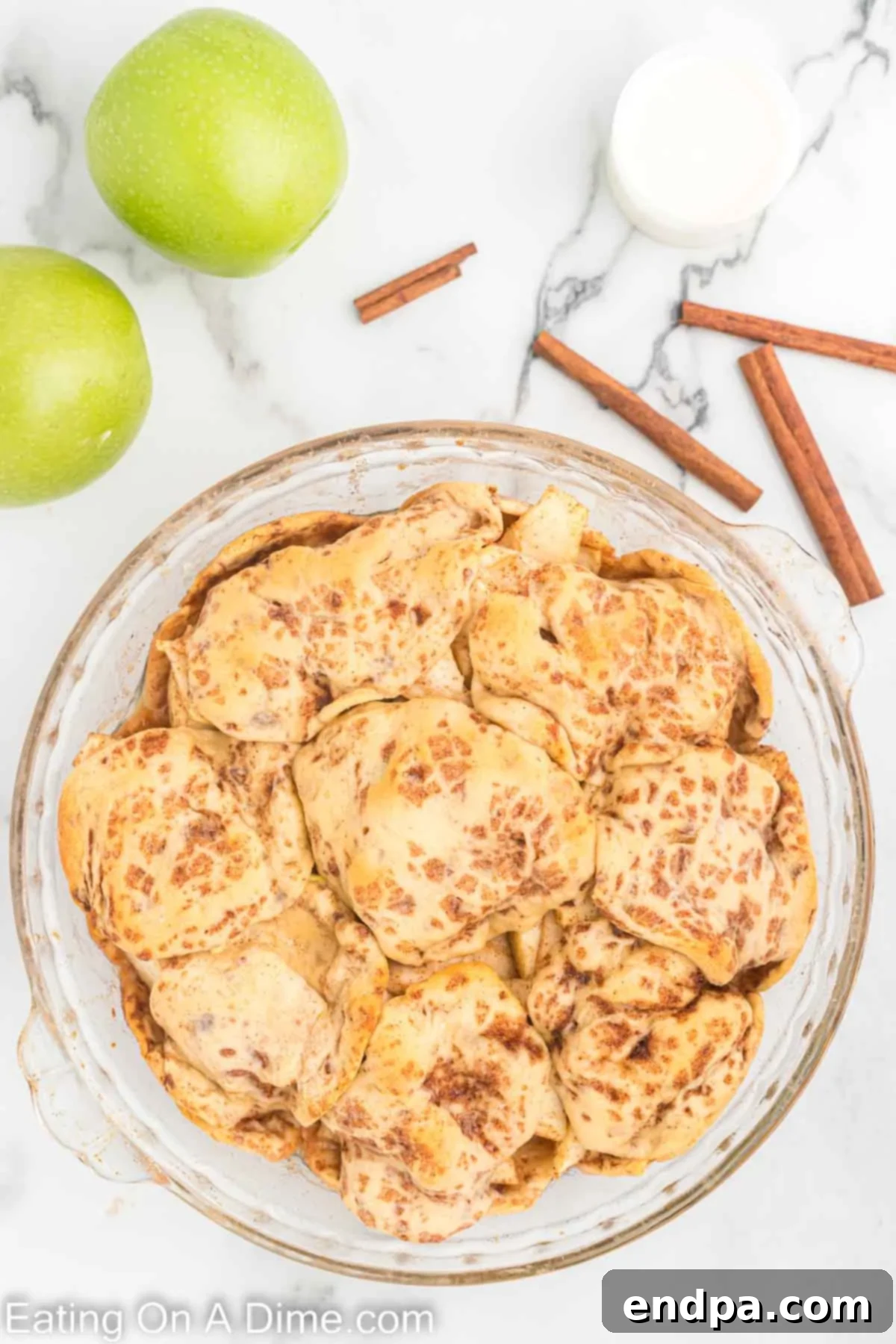 The remaining cinnamon roll pieces arranged over the apple filling to form the top crust of the pie.