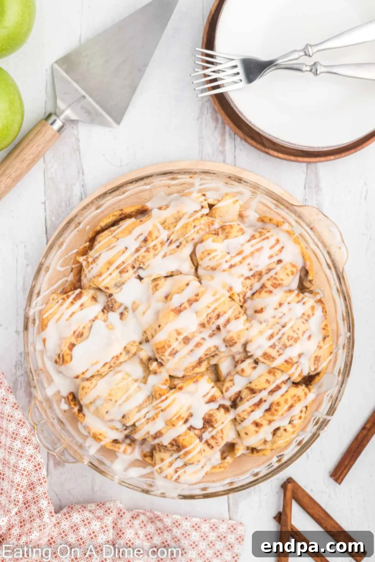 Finished Cinnamon Roll Apple Pie, freshly baked and glistening with a generous drizzle of the reserved cinnamon roll icing.