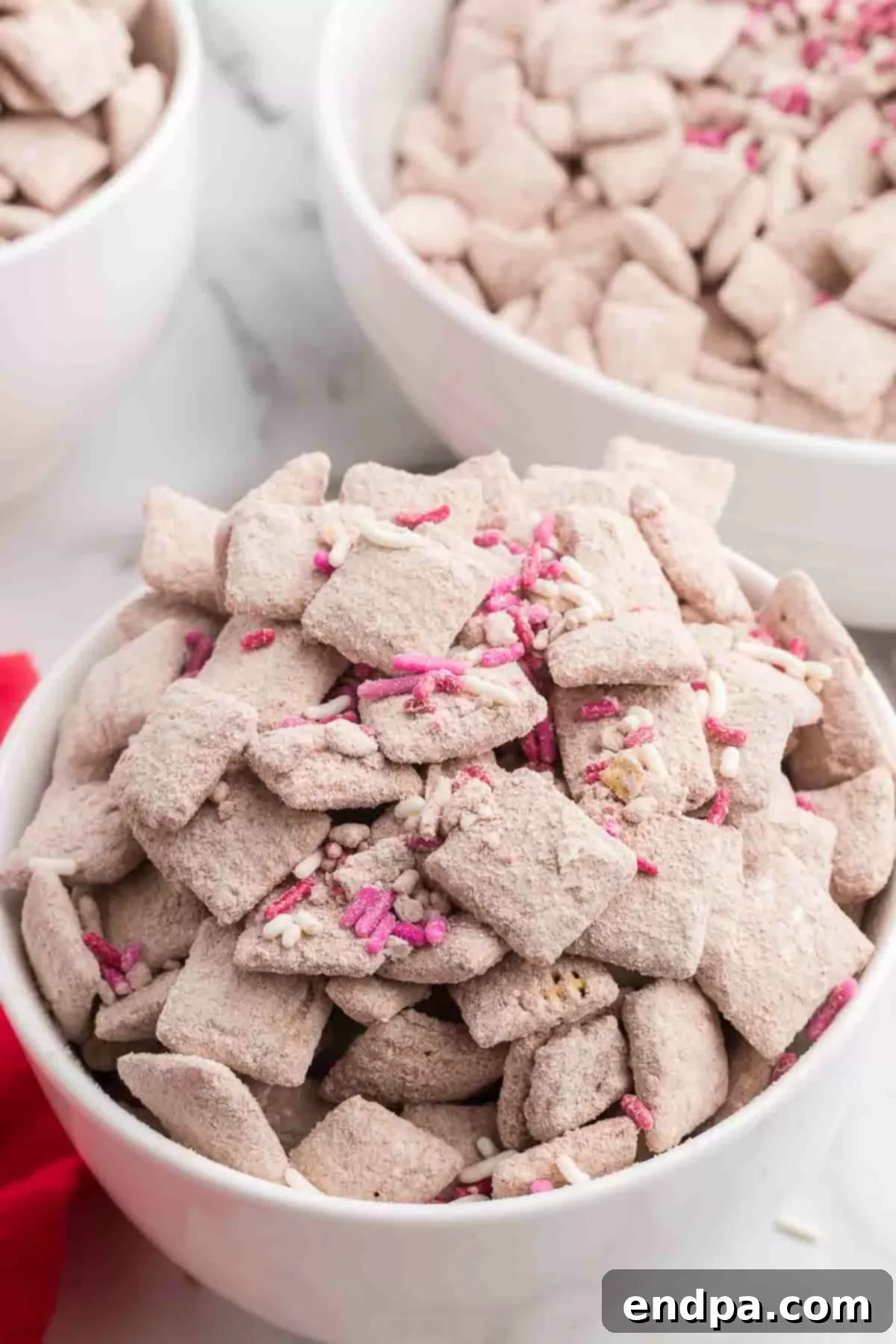 Red velvet puppy chow in a festive bowl, ready to be served as a delightful snack mix.