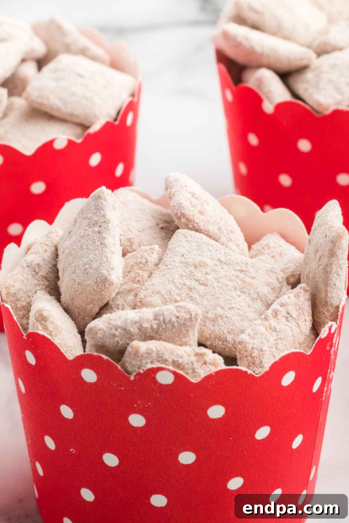 Red velvet puppy chow stored in a red airtight container, ready for travel or extended freshness.