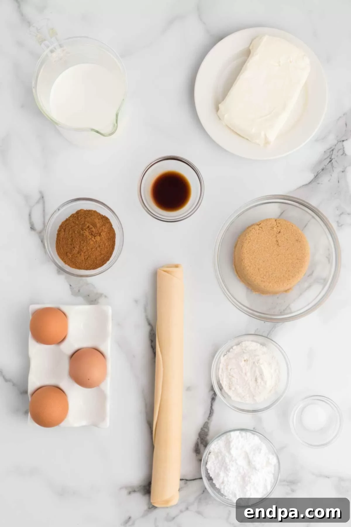 All the essential ingredients for a delicious cinnamon pie laid out on a rustic wooden surface, including a pie crust, cream cheese, brown sugar, eggs, half and half, flour, cinnamon, vanilla extract, salt, and powdered sugar.