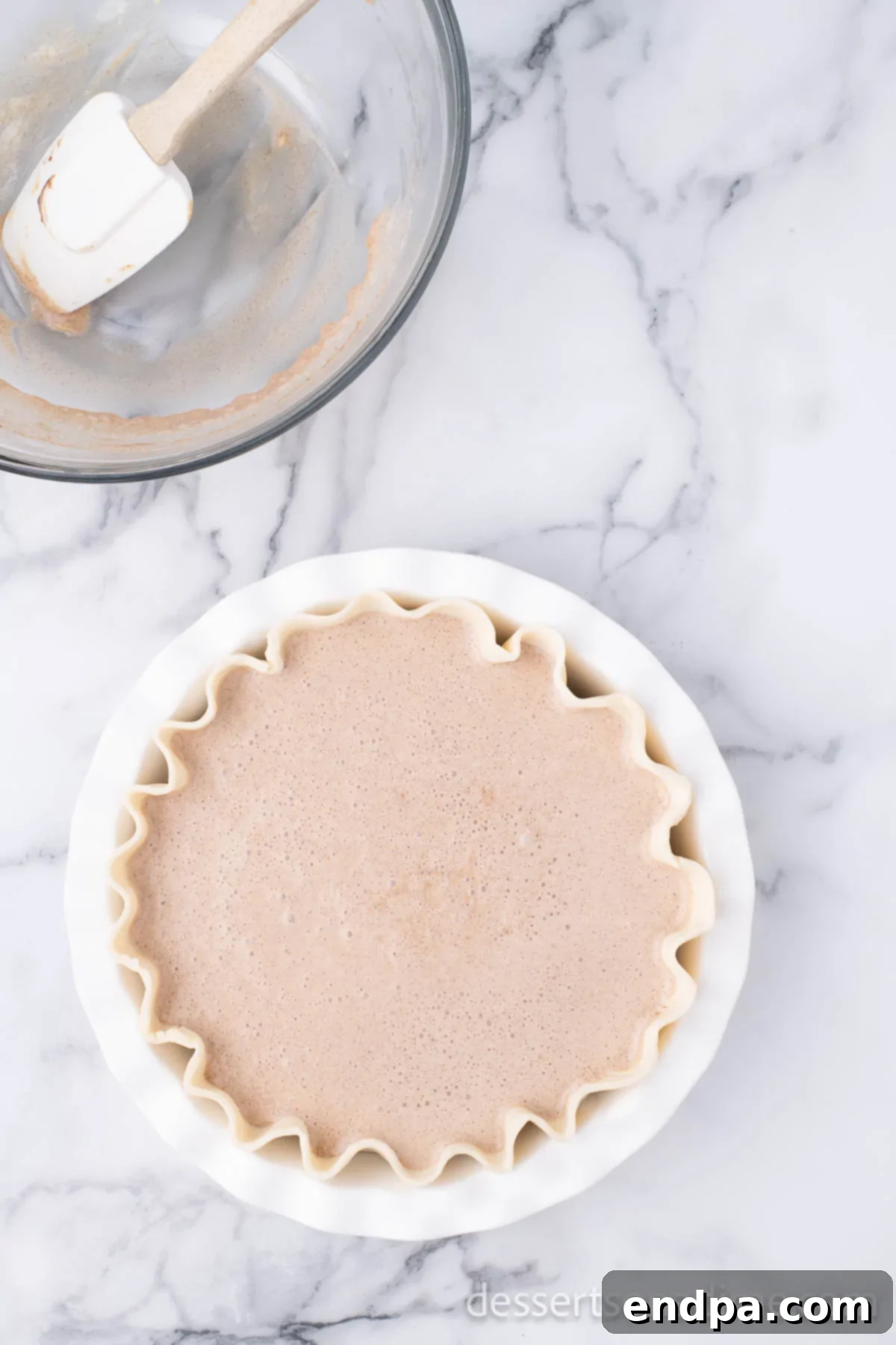 The smooth cinnamon pie filling has been poured into the chilled pie crust, ready for baking.