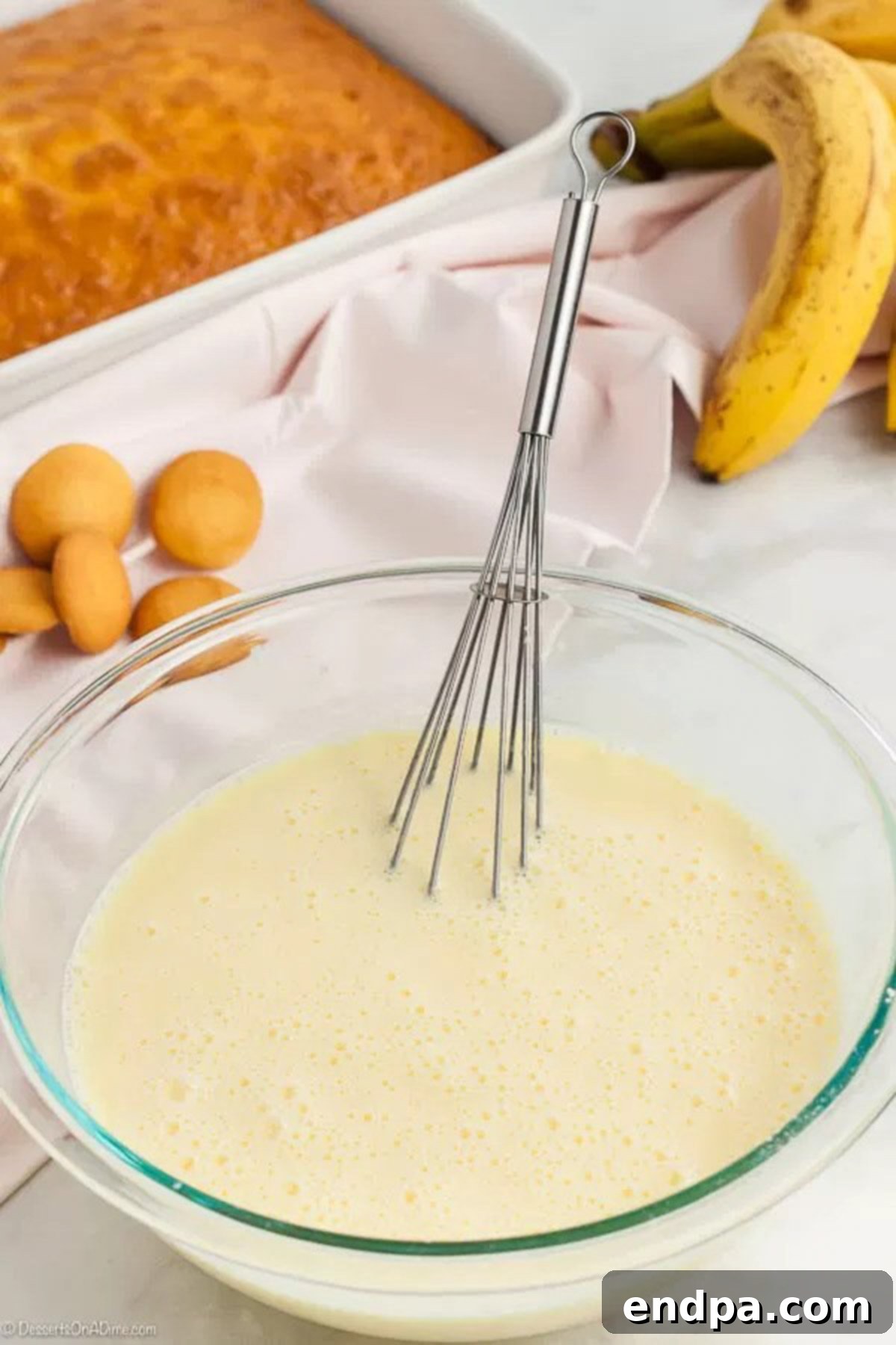 Banana Dream Pudding Cake 4 The pudding mix and milk being whisk together in a large bowl