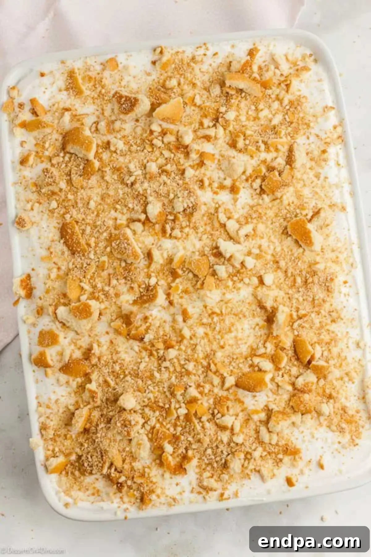 Banana Dream Pudding Cake 6 Crushed vanilla wafers sprinkled on top of the cool whip on top of the cake