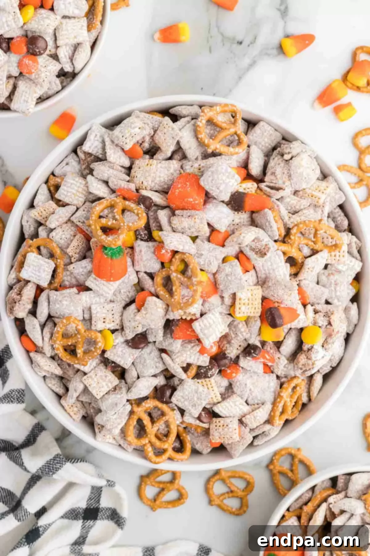 A large bowl filled with Harvest Puppy Chow, showcasing the festive mix of candies and pretzels.