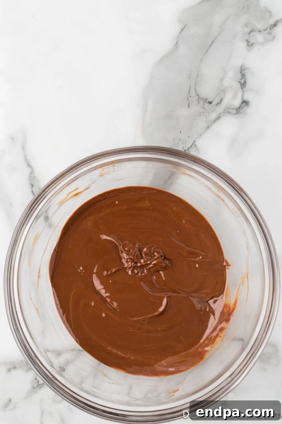 Melted chocolate, peanut butter, and butter mixture in a bowl, smooth and glossy.