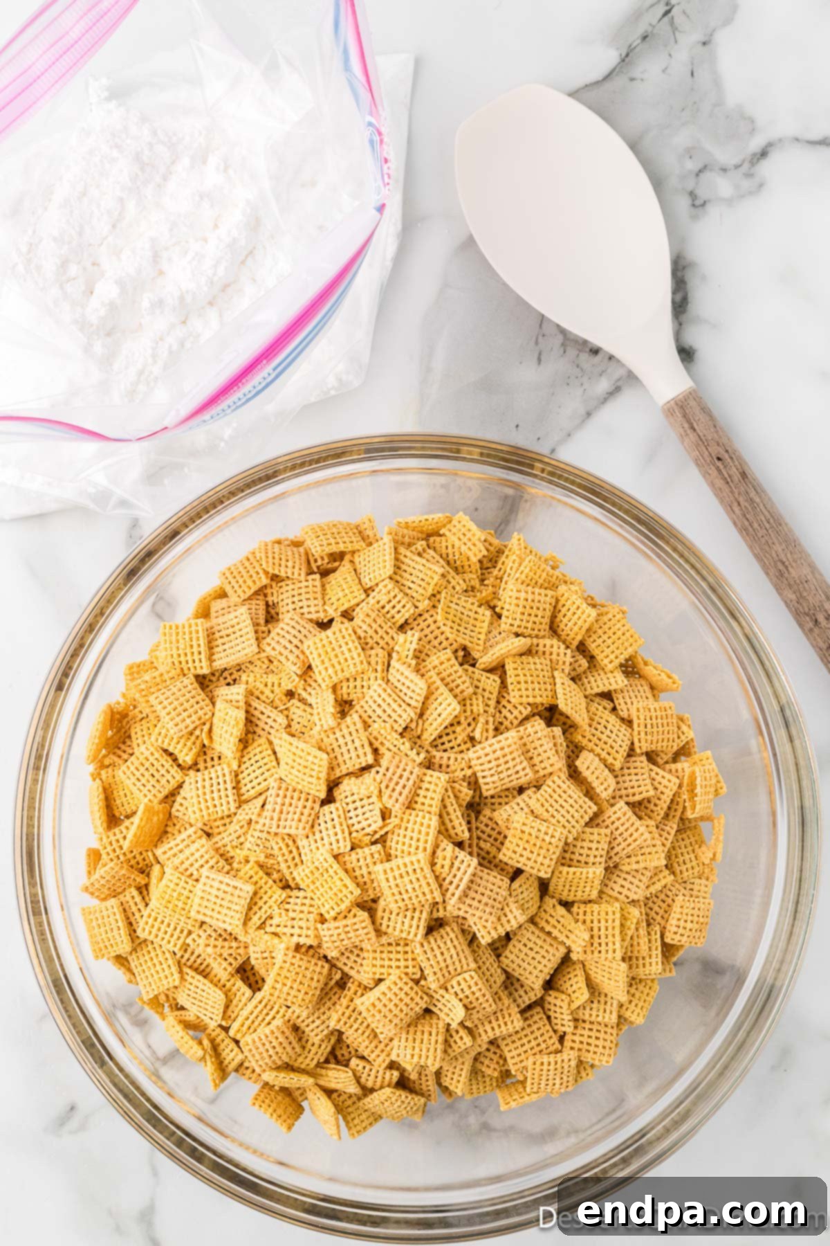 Chex cereal in a large mixing bowl, ready for coating.