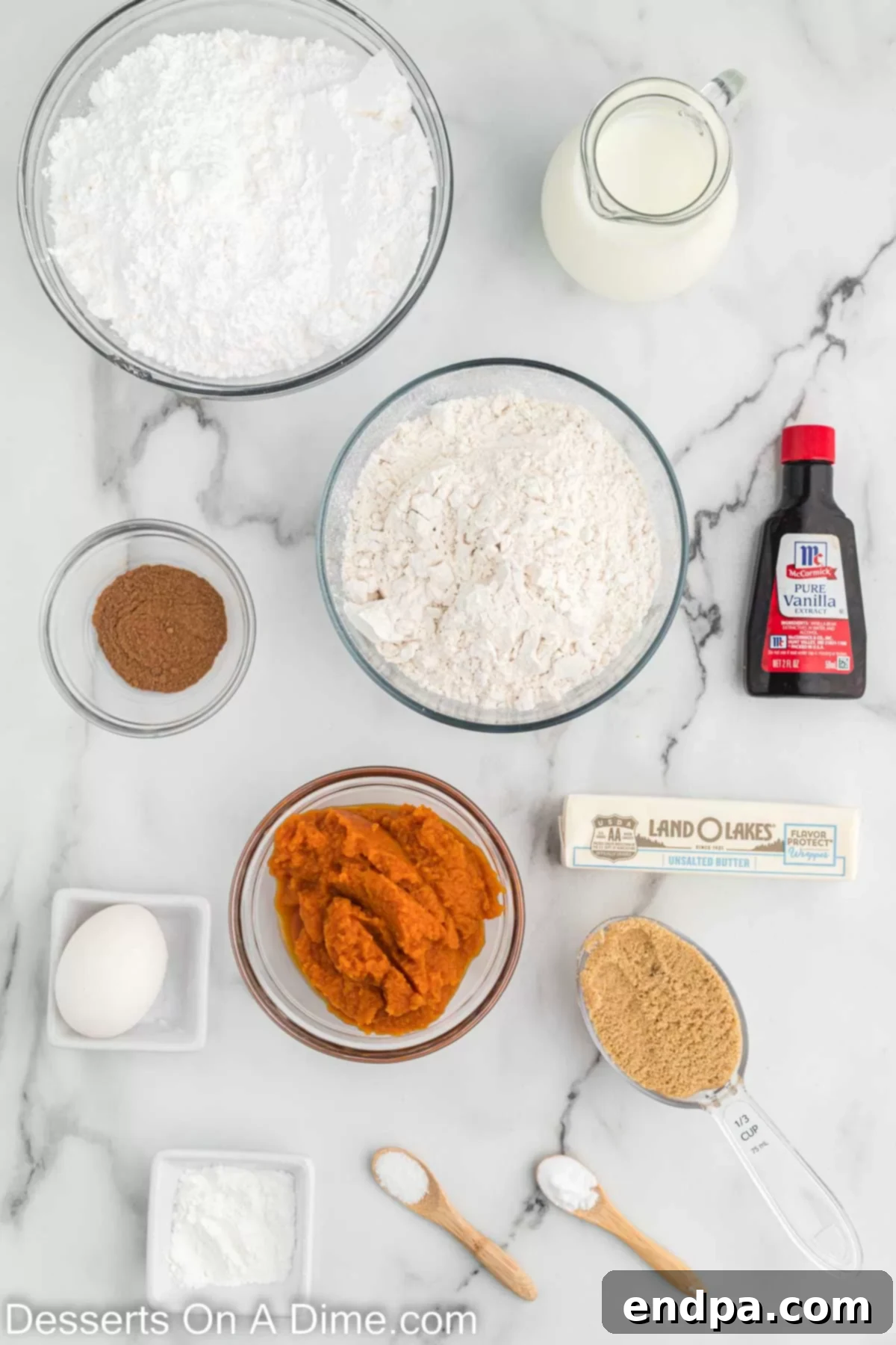 A vibrant display of ingredients for making Starbucks pumpkin scones, including flour, baking soda, brown sugar, butter, pumpkin puree, milk, egg, vanilla extract, and powdered sugar, all arranged on a rustic wooden surface.