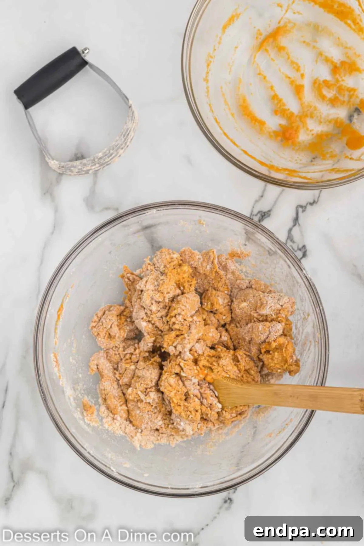 Wet ingredients (pumpkin puree, milk, egg, vanilla extract) being stirred into the dry ingredients, forming a cohesive scone dough.