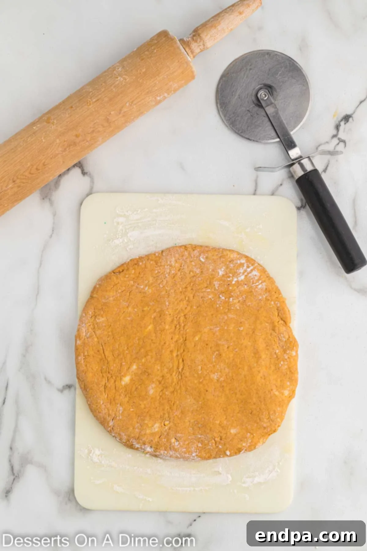 Scone dough rolled out into a circular shape on a lightly floured surface, ready for cutting into triangles.