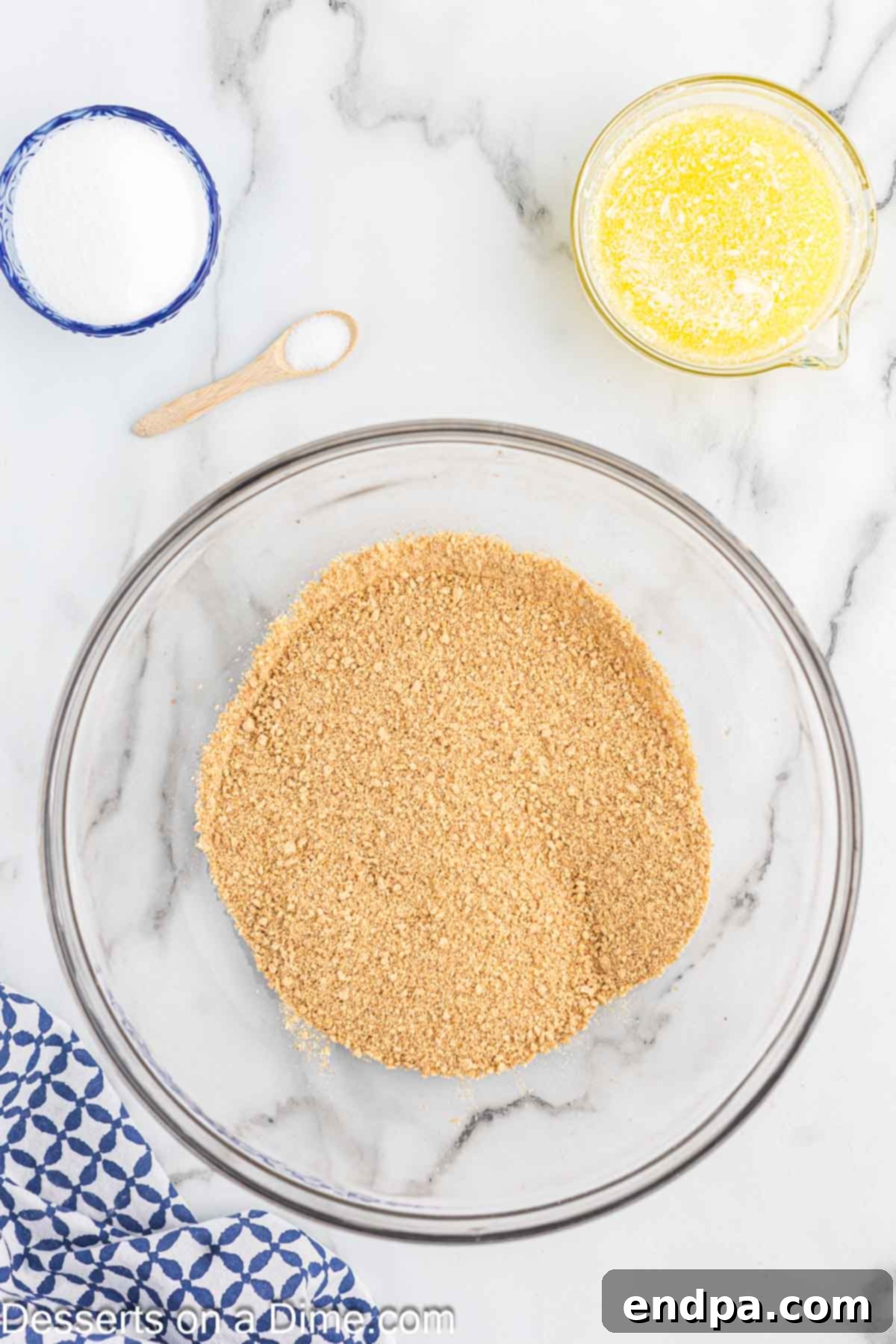 Fine graham cracker crumbs collected in a medium-sized mixing bowl, ready for the next ingredients.