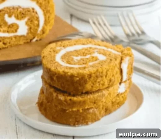 Beyond Pie: Thanksgiving Cake Recipes 8 A slice of Easy Pumpkin Roll, featuring a beautiful spiral of pumpkin cake and cream cheese filling.