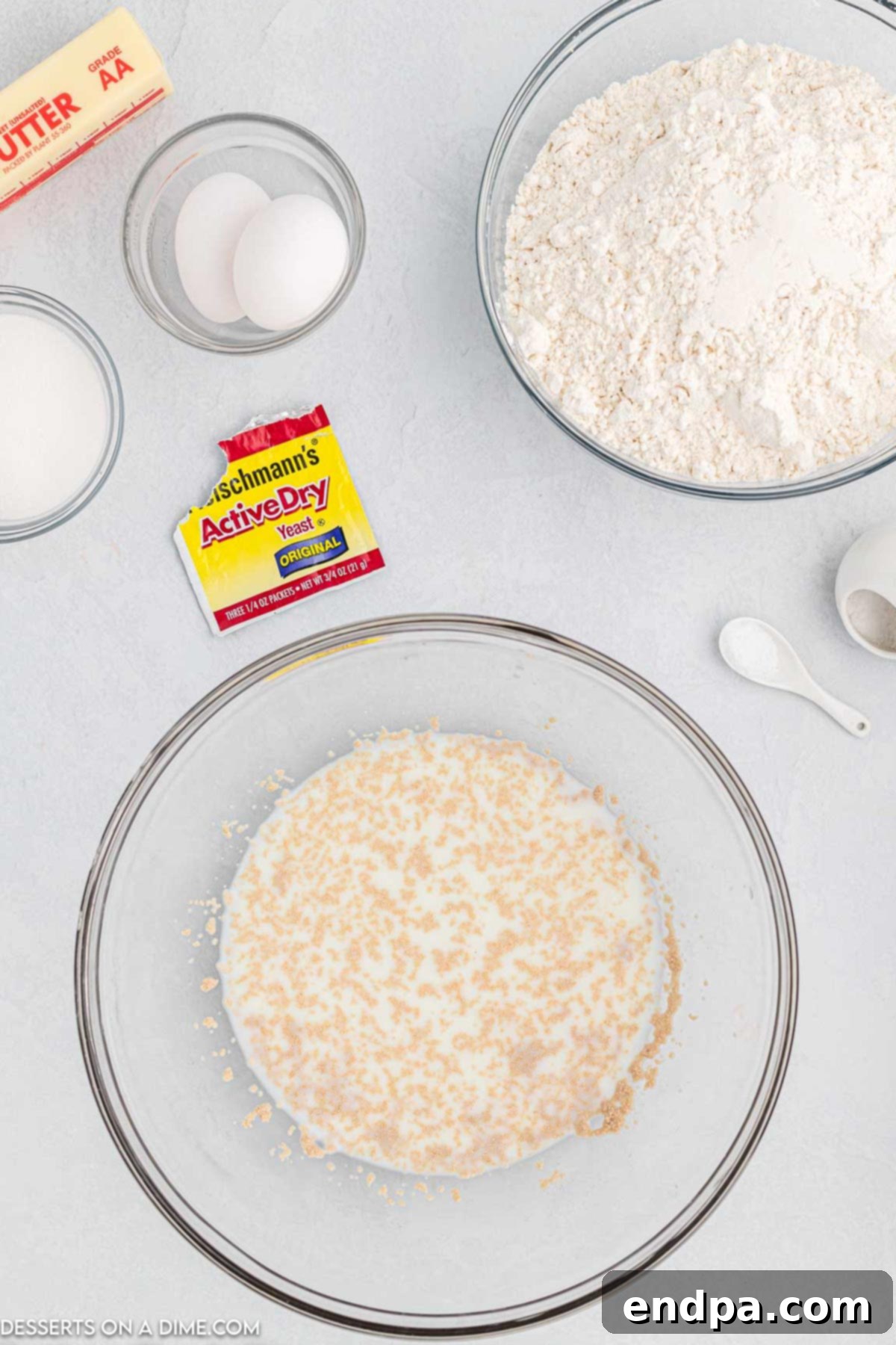 Crafting Perfect Cinnabon Cinnamon Rolls 4 Warm milk and active dry yeast combining in a large bowl, showing the yeast activating with froth and bubbles.