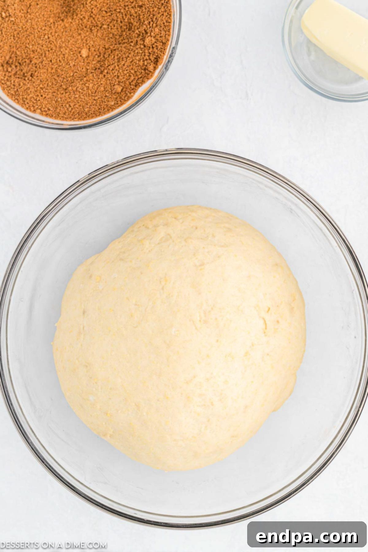 Crafting Perfect Cinnabon Cinnamon Rolls 6 Cinnamon roll dough in an oiled mixing bowl, covered with a kitchen towel and rising.